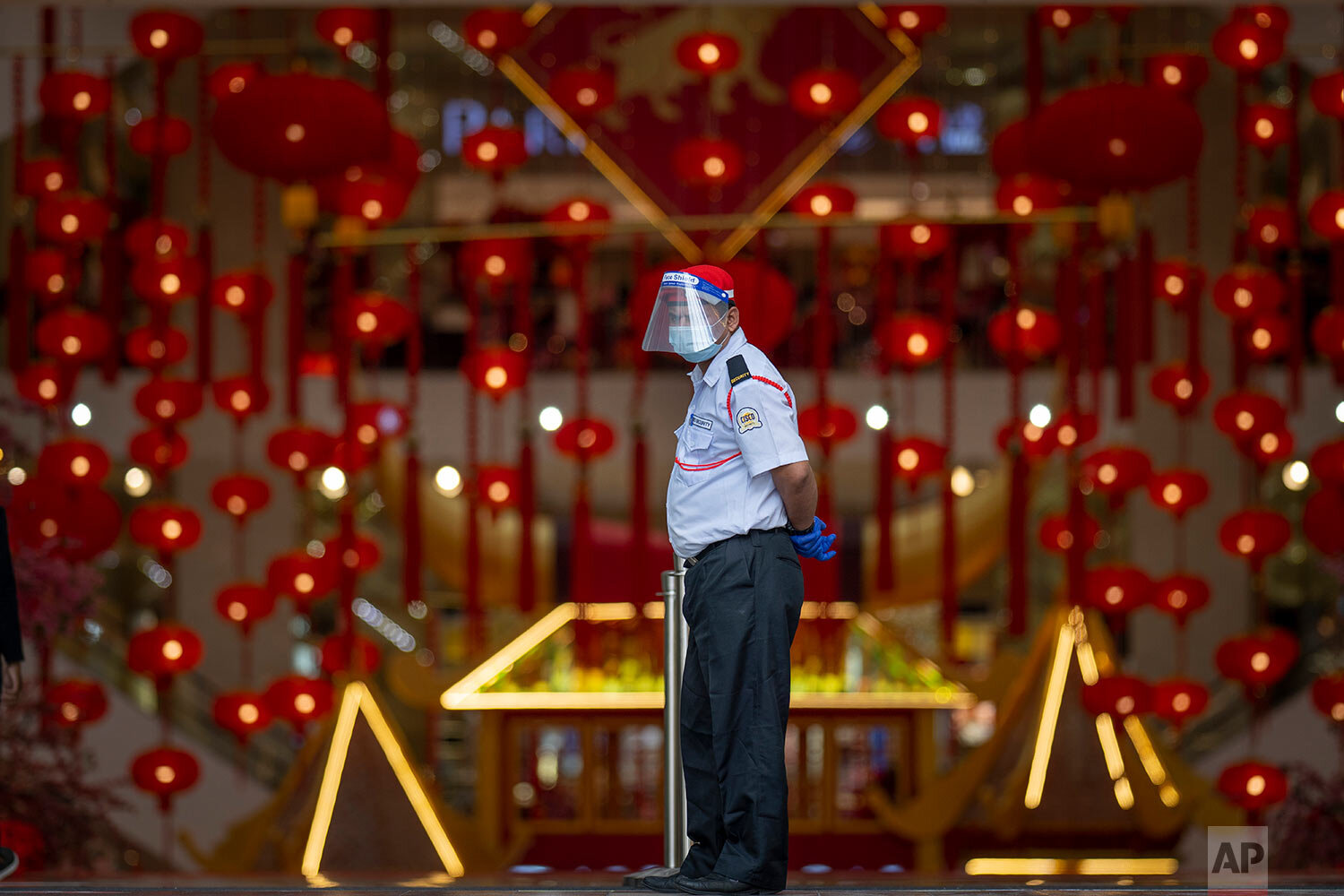  A security person wearing a face shield and face mask guards at the entrance of a shopping mall in Kuala Lumpur, Malaysia Thursday, Jan. 14, 2021. (AP Photo/Vincent Thian) 