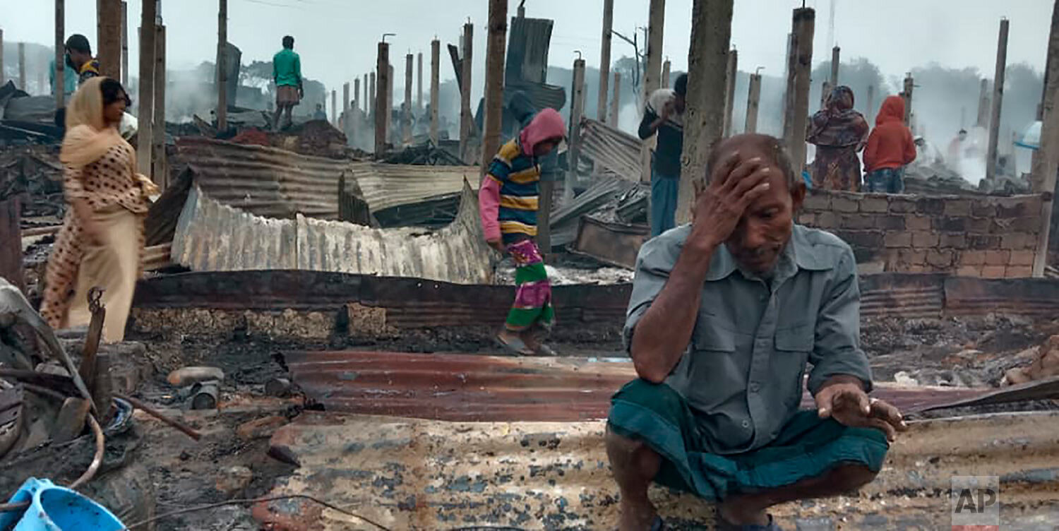  A Rohingya refugee sits by the charred remains after a fire broke out in Nayapara Camp in Cox's Bazar district, Bangladesh, Thursday, Jan. 14, 2021. (AP Photo/Mohammed Faisal) 