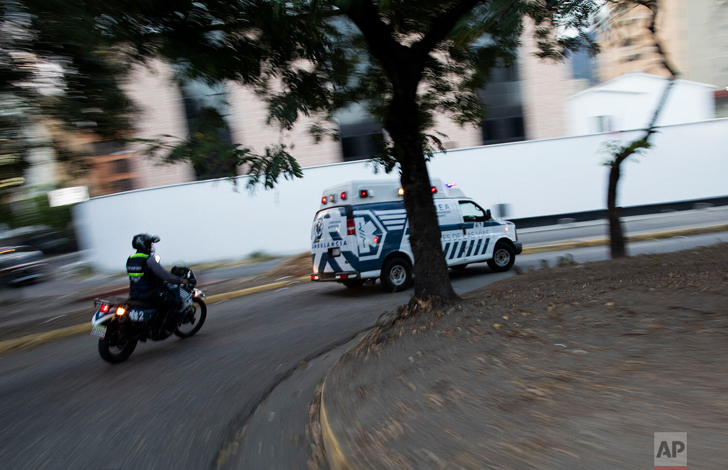  An Angels of the Road volunteer paramedic follows on a motorcycle their single ambulance transporting a patient who was injured in a road accident, in Caracas, Venezuela, Wednesday, Feb. 10, 2021. (AP Photo/Ariana Cubillos) 
