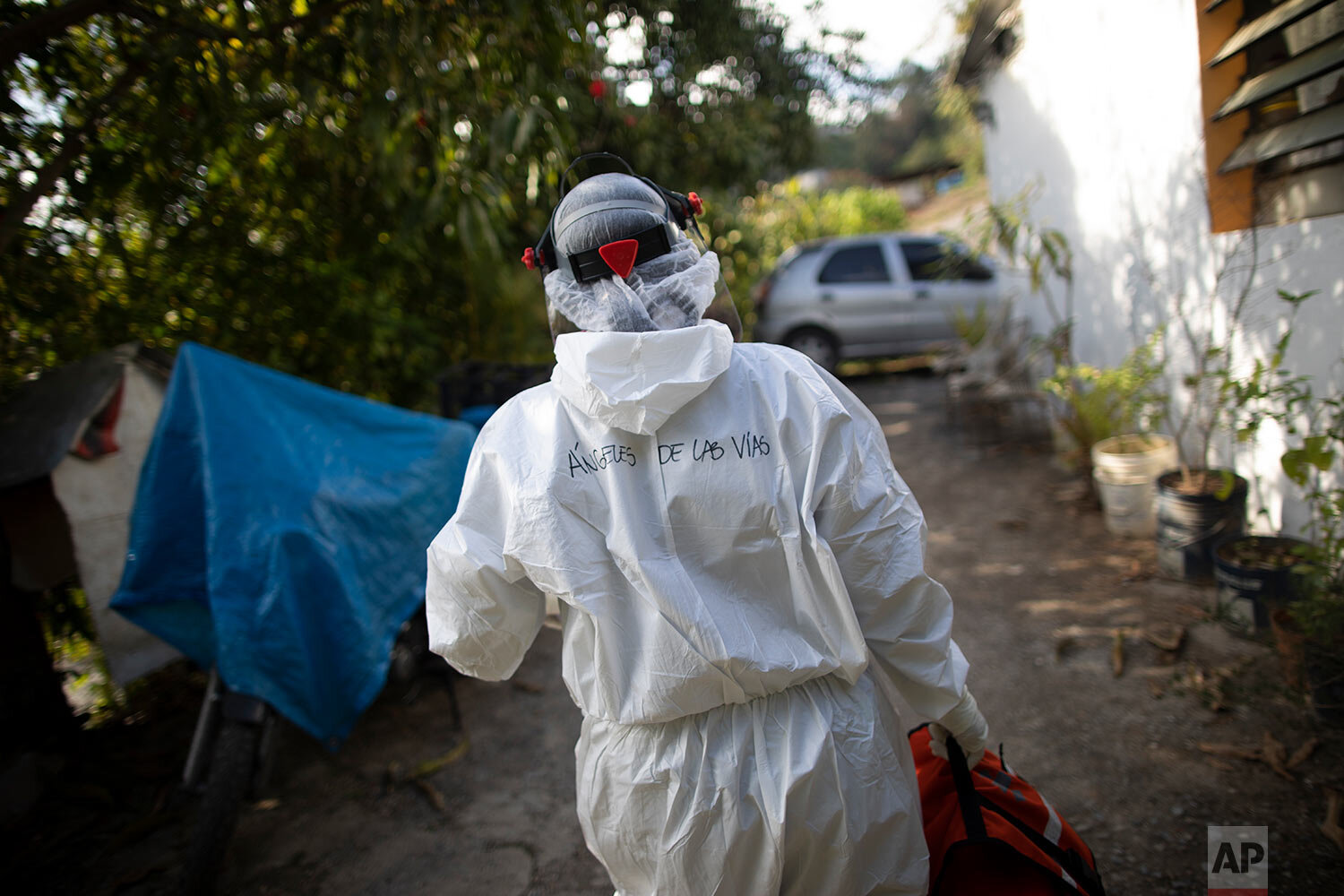  Wearing a biosecurity suit, Dr. Debora Mejia, an Angels of the Road volunteer, walks out of a house after visiting two COVID-19 patients in Caracas, Venezuela, Wednesday, Feb. 3, 2021.  (AP Photo/Ariana Cubillos) 