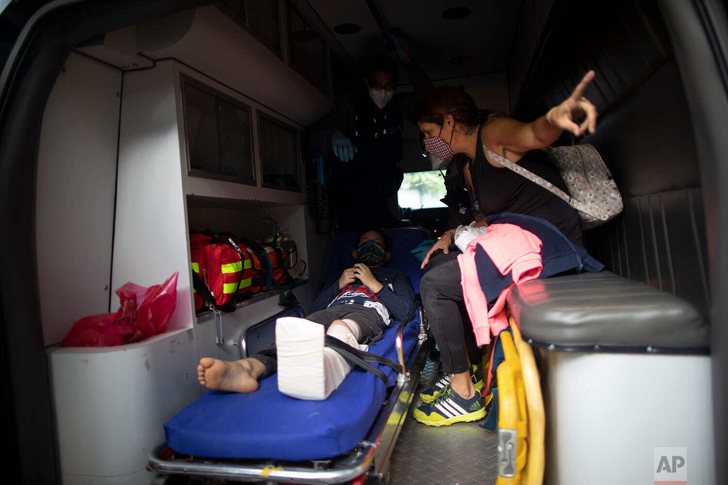  A boy who was involved in a motorcycle accident is transported to the hospital by Angels of the Road volunteer paramedics in their only ambulance in Caracas, Venezuela, Thursday, Feb. 4, 2021. (AP Photo/Ariana Cubillos) 