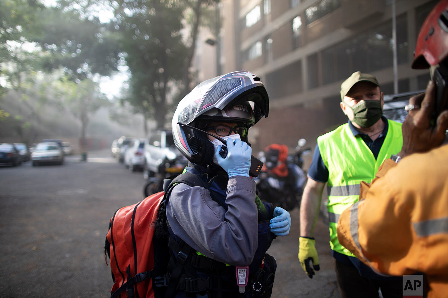  Angels of the Road volunteer paramedic Zully Rodiz speaks on the radio as she arrives to a car fire at a parking lot in Caracas, Venezuela, Monday, Feb. 8, 2021. (AP Photo/Ariana Cubillos) 