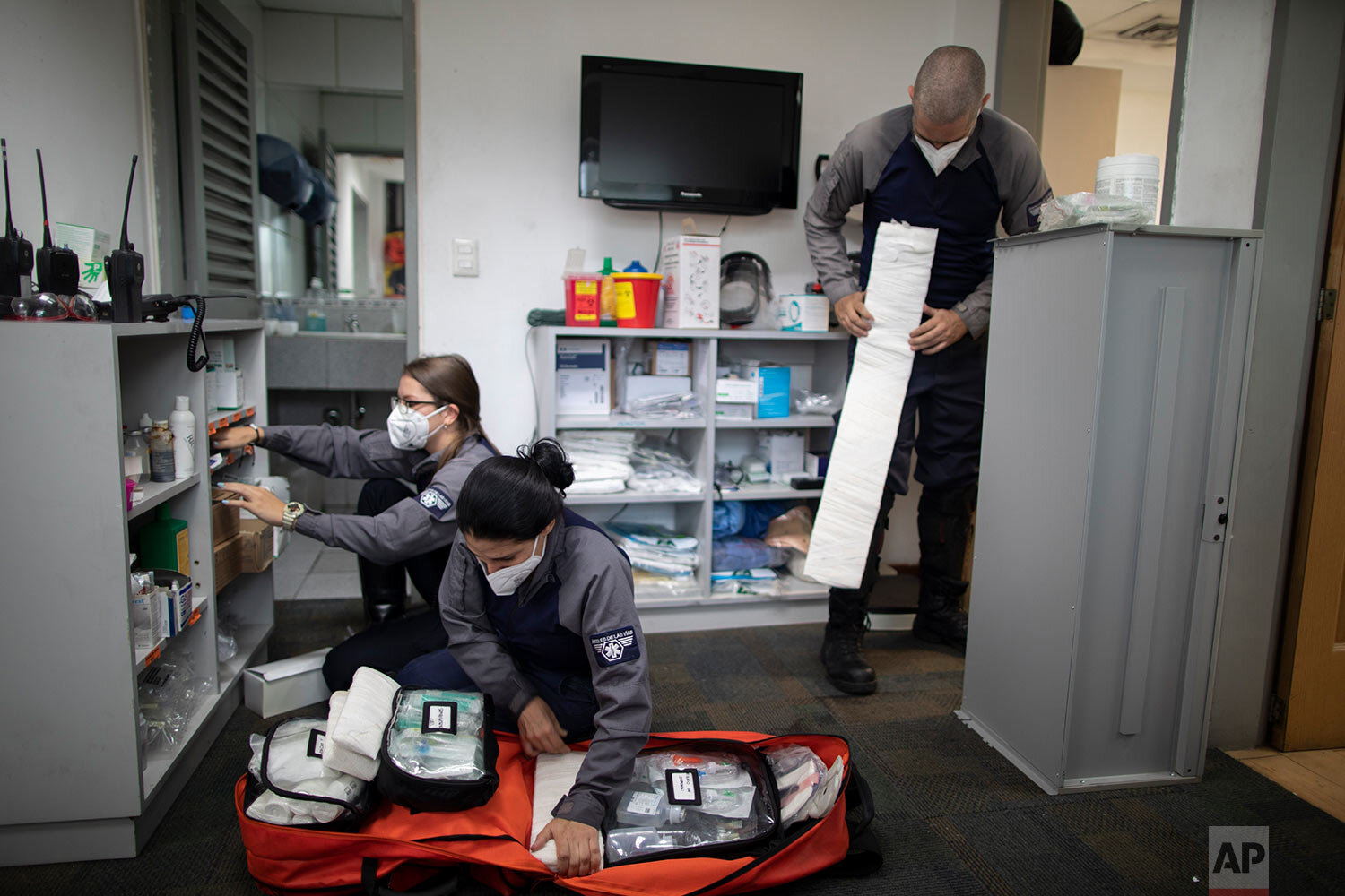  Wearing masks as a precaution against the new coronavirus, Angels of the Road volunteer paramedics, Laura Lara, from left, Zully Rodiz and Jonathan Quantip, resupply their trauma kit, in Caracas, Venezuela, Monday, Feb. 8, 2021. (AP Photo/Ariana Cub