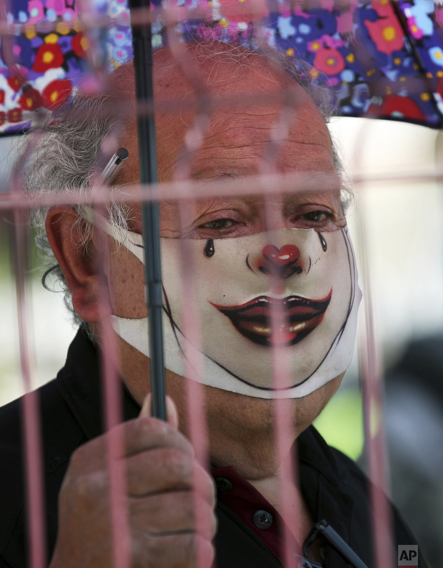  An elderly man with a mask painted as a clown waits in line for his dose of the Sinovac COVID-19 vaccine at a sports center in Ecatepec, a borough on the outskirts of Mexico City, Feb. 23, 2021. (Foto AP/Marco Ugarte 