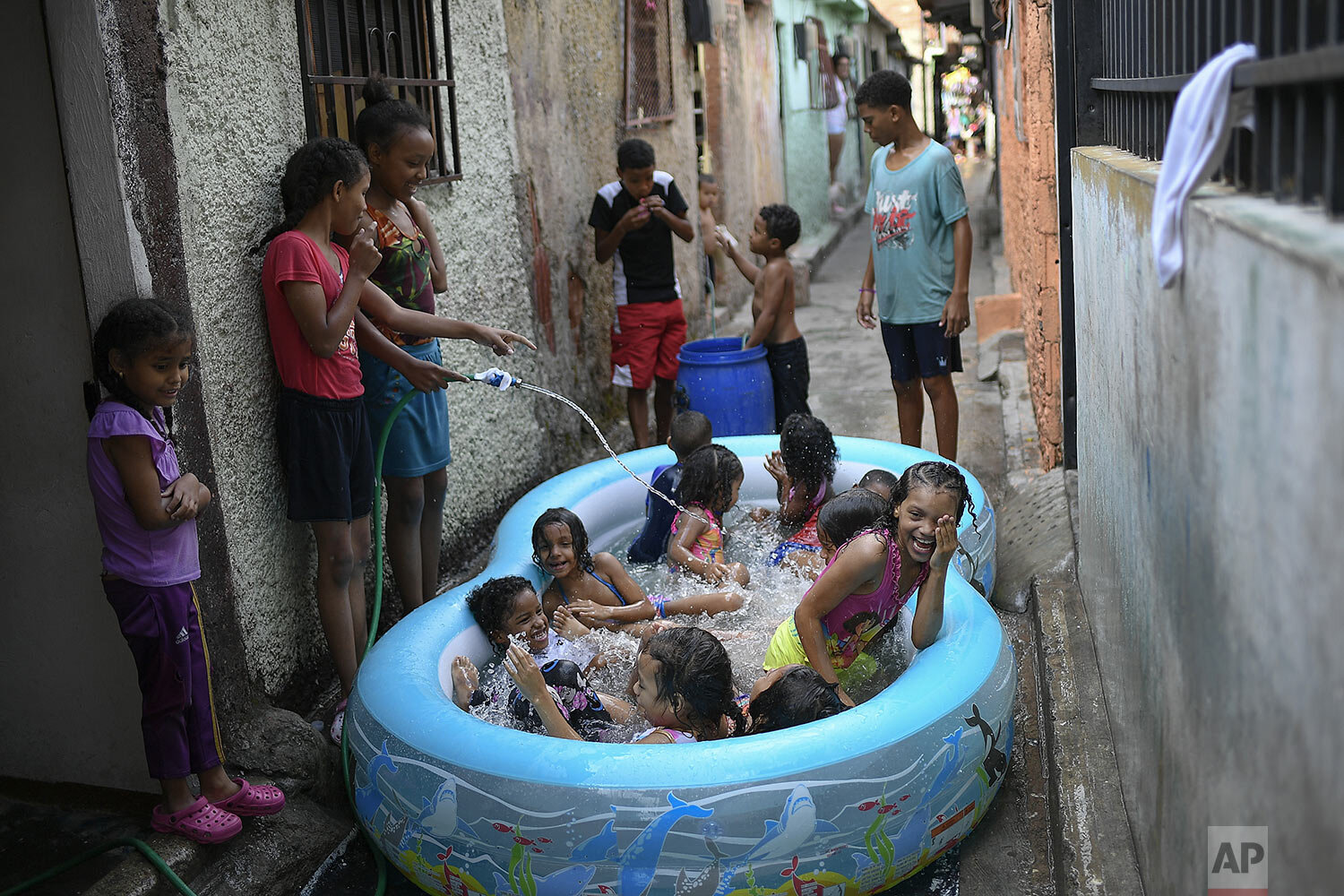 Children play in an inflatable pool during carnival in the Pinto Salinas neighborhood of Caracas, Venezuela, Feb. 15, 2021. (AP Photo/Matias Delacroix) 