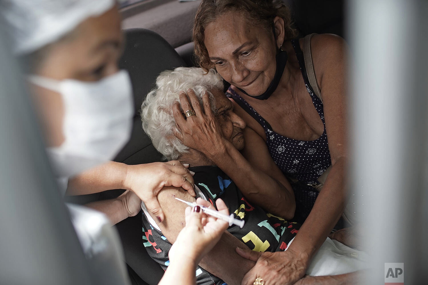  An elderly woman gets a shot of China's Sinovac vaccine as part of a priority COVID-19 vaccination program for the elderly at a drive-thru vaccination center in Rio de Janeiro, Brazil, Feb. 1, 2021. (AP Photo/Silvia Izquierdo) 