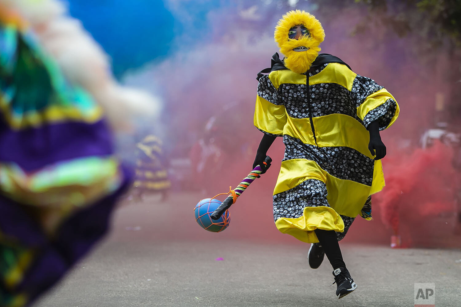  A man dressed in a costume known as "fantasias" runs during a brief appearance as part of a Carnival tradition in spite of COVID-19 pandemic restrictions in Rio de Janeiro, Brazil, Feb. 13, 2021. (AP Photo/Bruna Prado) 