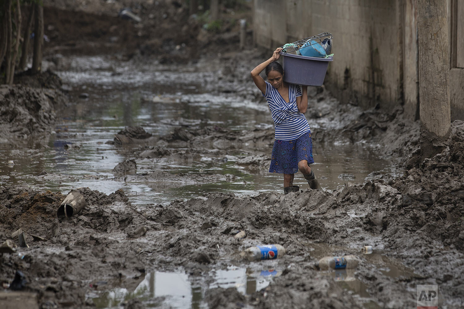  A resident continues to extract items from her home after it was flooded by last year's hurricanes Eta and Iota in San Pedro Sula, Honduras,, Jan. 12, 2021. (AP Photo/Moises Castillo) 