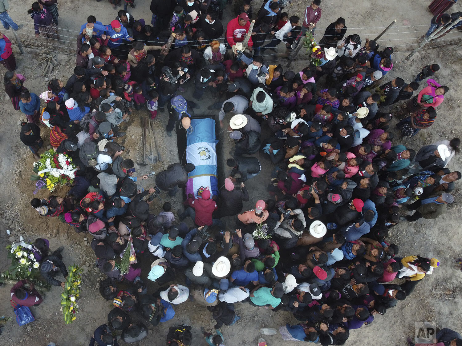 People lower the remains of Elfego Miranda Diaz into a grave, a Guatemalan migrant who was killed near the U.S.-Mexico border in January, at a cemetery in Comitancillo, Guatemala, March 13, 2021. Residents received the remains of 16 of their own, fo