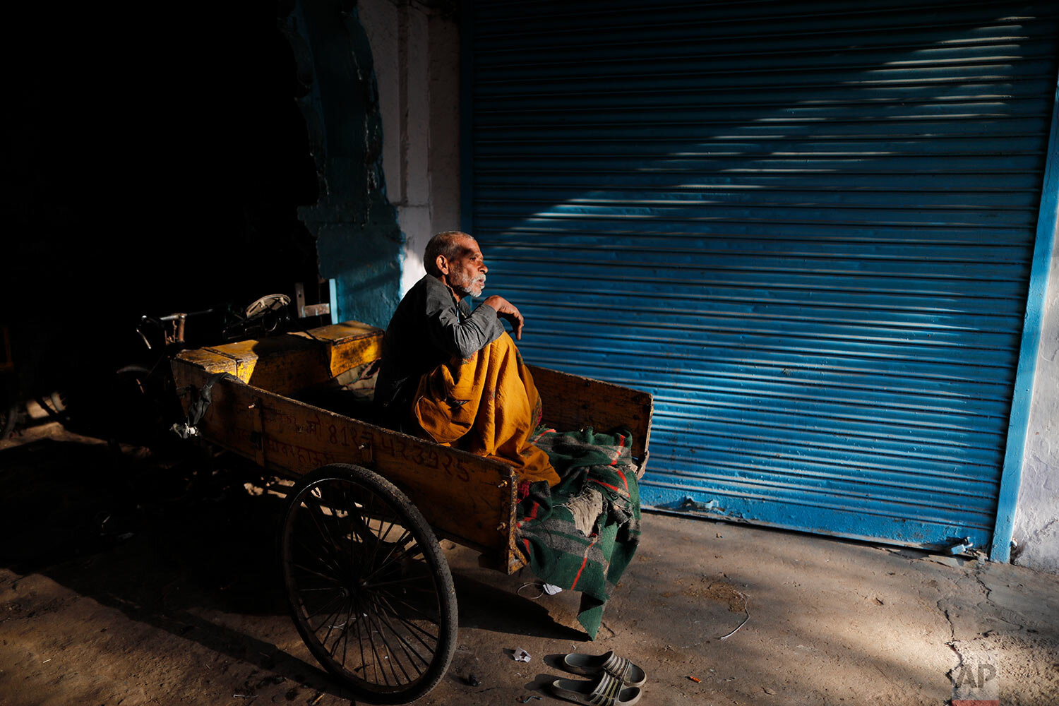  A rickshaw puller rests on the back of his cycle rickshaw at a market in Prayagraj, India, Wednesday, March 3, 2021. (AP Photo/Rajesh Kumar Singh) 