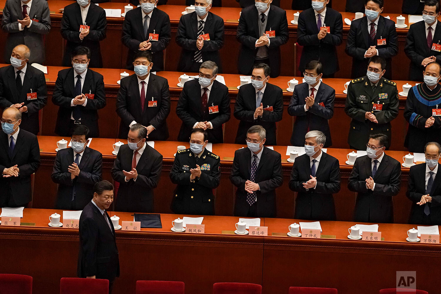  Delegates wearing face masks to help curb the spread of the coronavirus applaud as Chinese President Xi Jinping arrives for the opening session of Chinese People's Political Consultative Conference (CPPCC) at the Great Hall of the People in Beijing,