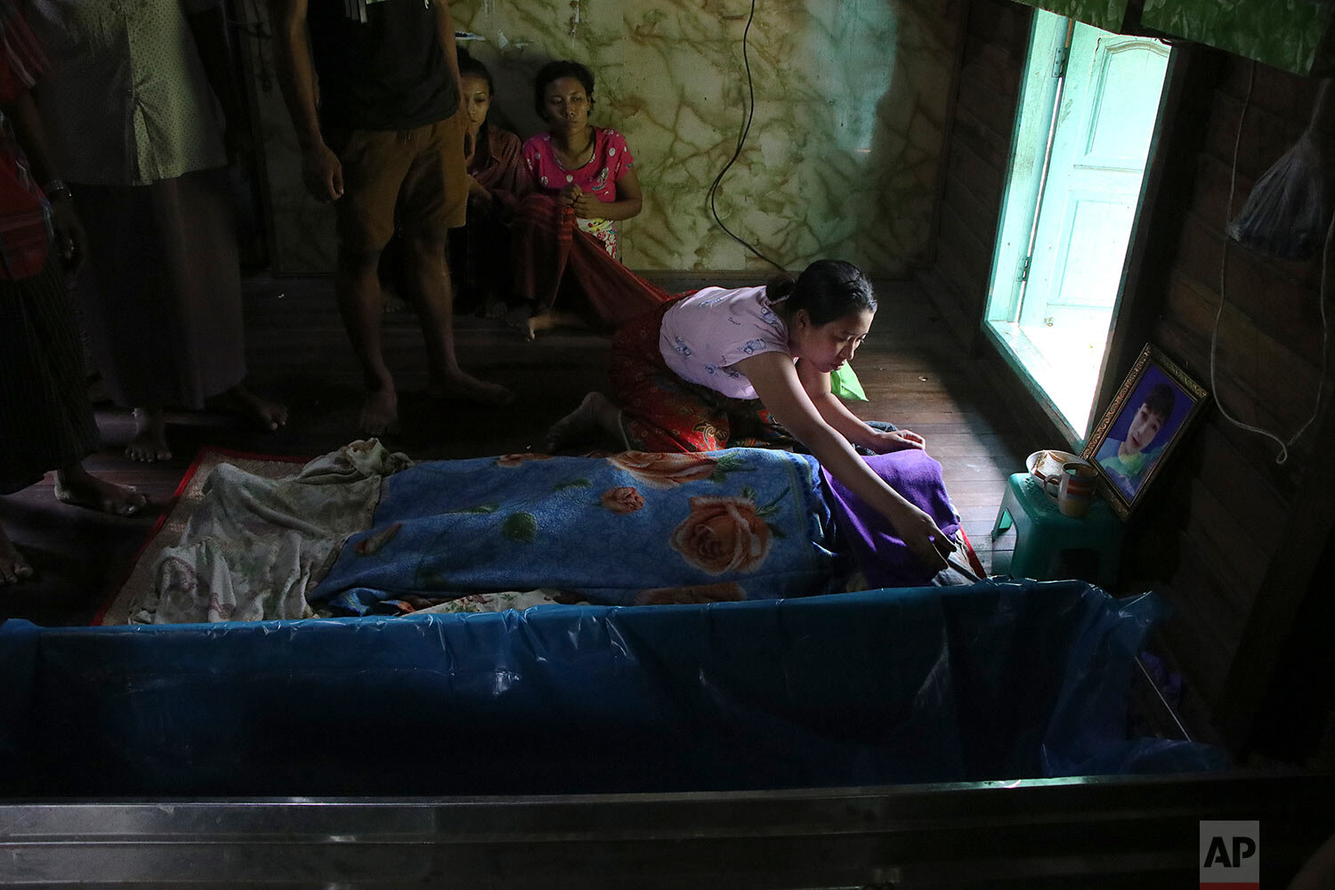  Friends and relatives mourn Saturday, March 27, 2021, over the body of Kyaw Htet Aung, 17, who was fatally shot in the neck by soldiers in Dala Township, Yangon, Myanmar. (AP Photo) 