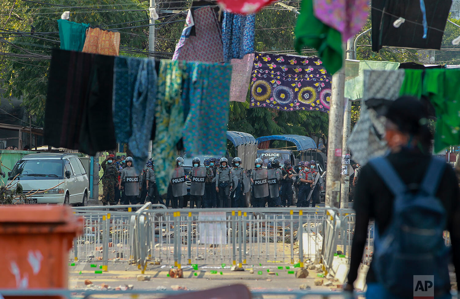 Anti-coup protesters stand behind a line of women's clothing hanging across a road to deter security personnel from entering the protest area in Yangon, Myanmar Tuesday, March 9, 2021. (AP Photo) 