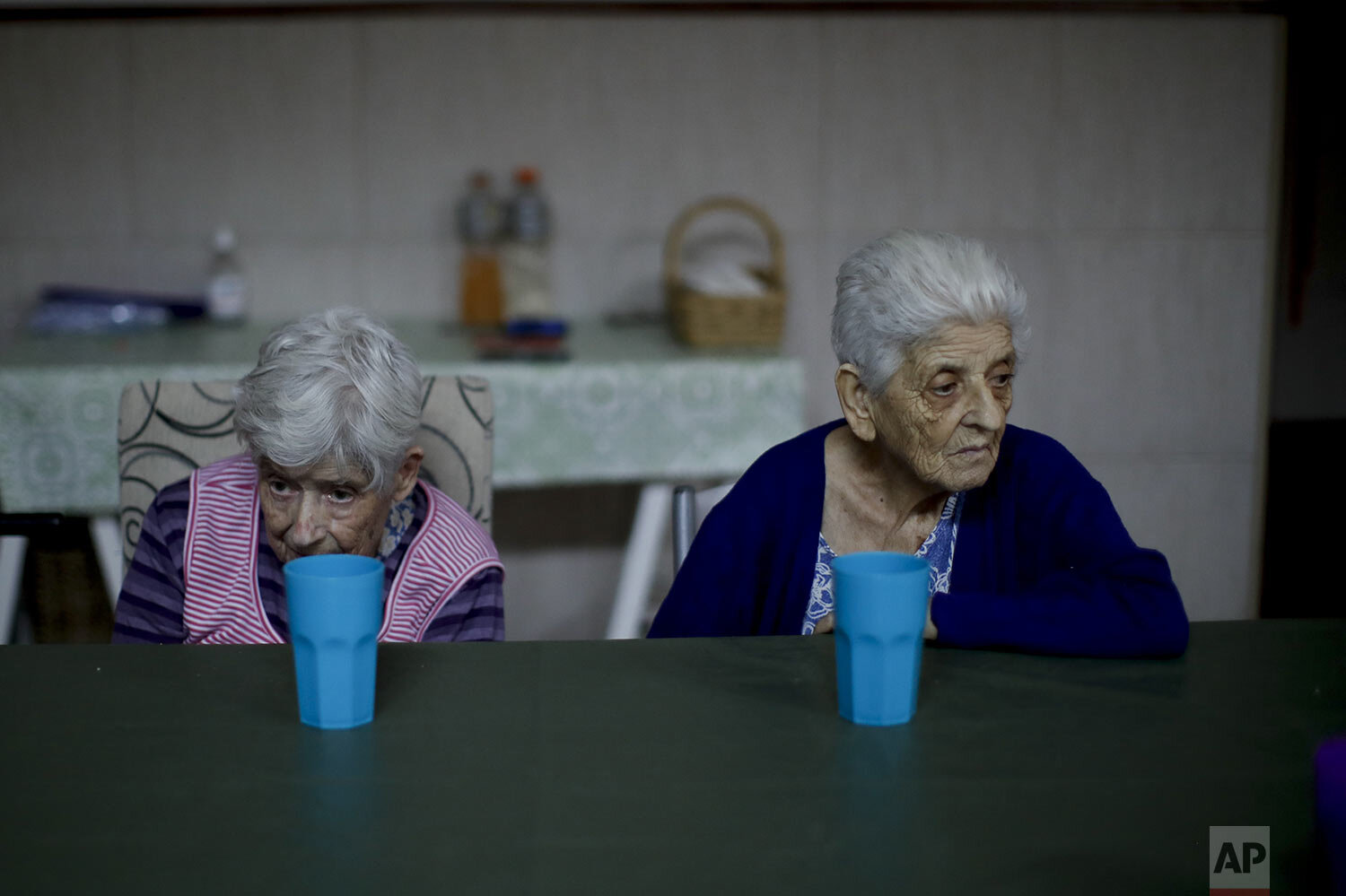  Elderly women rest at a table during a pause between activities at the Reminiscencias residence for the elderly in Tandil, Argentina, Sunday, April 4, 2021. (AP Photo/Natacha Pisarenko) 