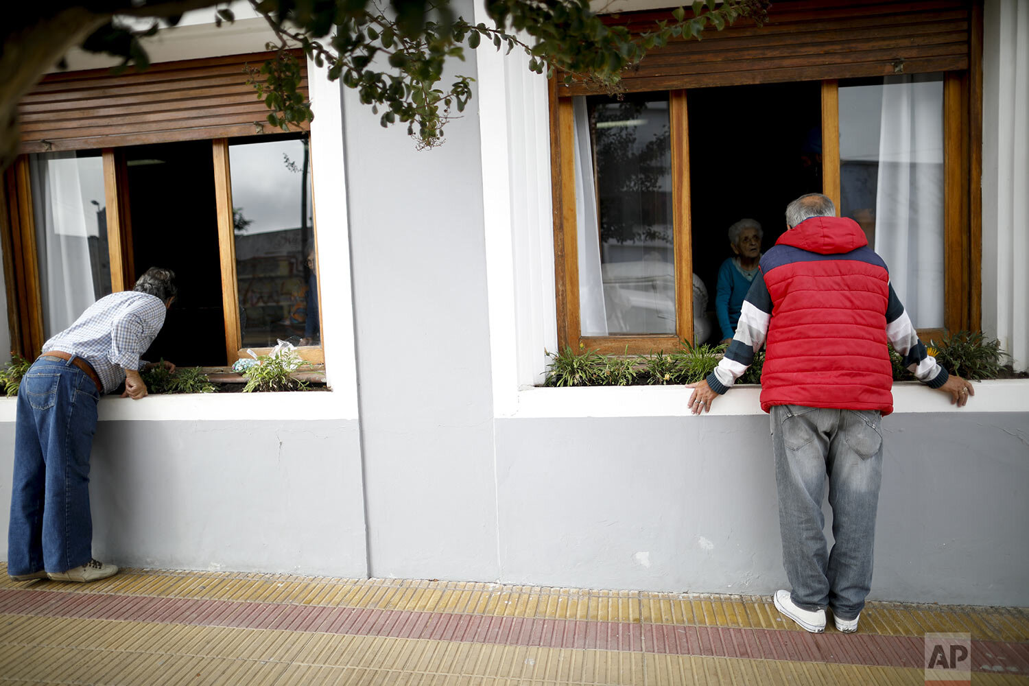  Men visit their mothers living at the Reminiscencias residence for the elderly in Tandil, Argentina, Monday, April 5, 2021. (AP Photo/Natacha Pisarenko) 