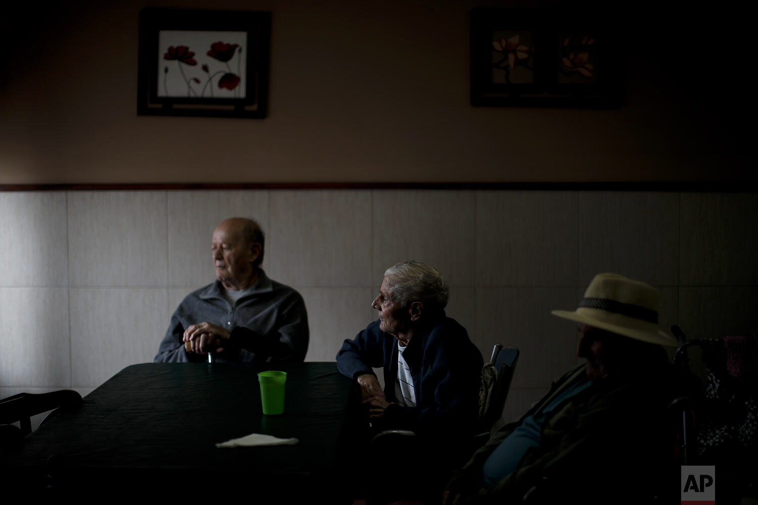  Fermin Urban, left, Victor Tripiana, center, and Pedro Aberastegui rest during a break between activities at the Reminiscencias residence for the elderly in Tandil, Argentina, Monday, April 5, 2021. (AP Photo/Natacha Pisarenko) 