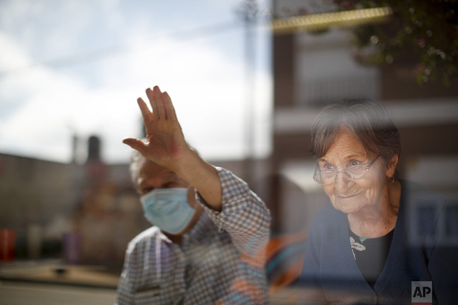  Arceli Armando watches her son wave to her from outside of the Reminiscencias residence for the elderly where she lives in Tandil, Argentina, Monday, April 5, 2021. (AP Photo/Natacha Pisarenko) 