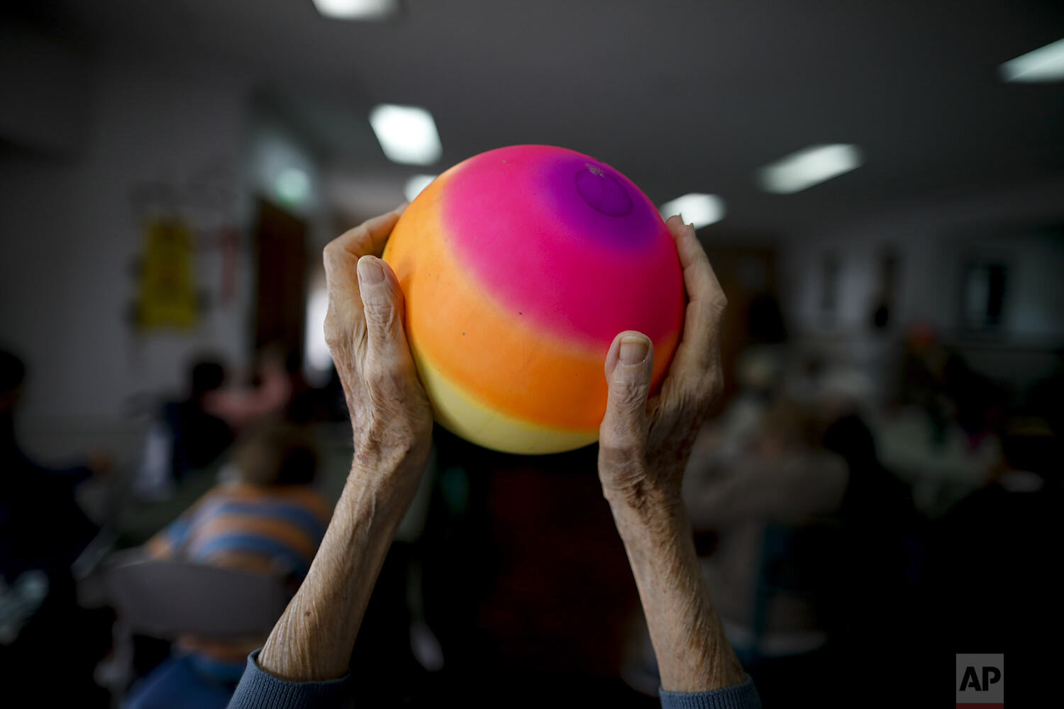  Delia Solbach holds up a ball during an exercise class at the Reminiscencias residence for the elderly in Tandil, Argentina, Monday, April 5, 2021. (AP Photo/Natacha Pisarenko) 