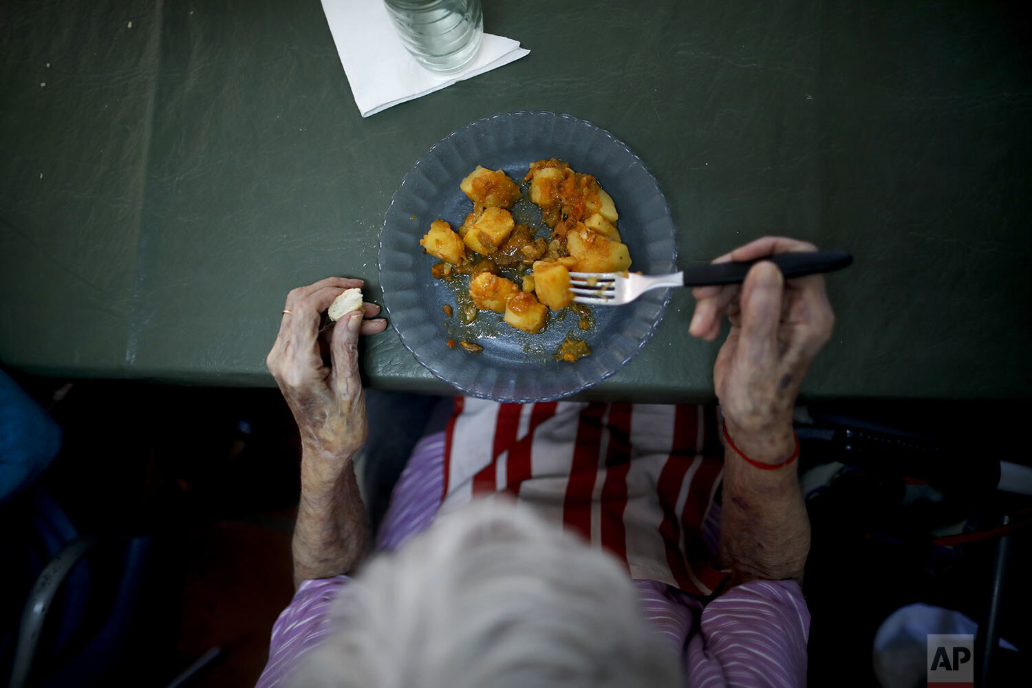  A woman eats lunch at the Reminiscencias residence for the elderly in Tandil, Argentina, Monday, April 5, 2021. (AP Photo/Natacha Pisarenko) 