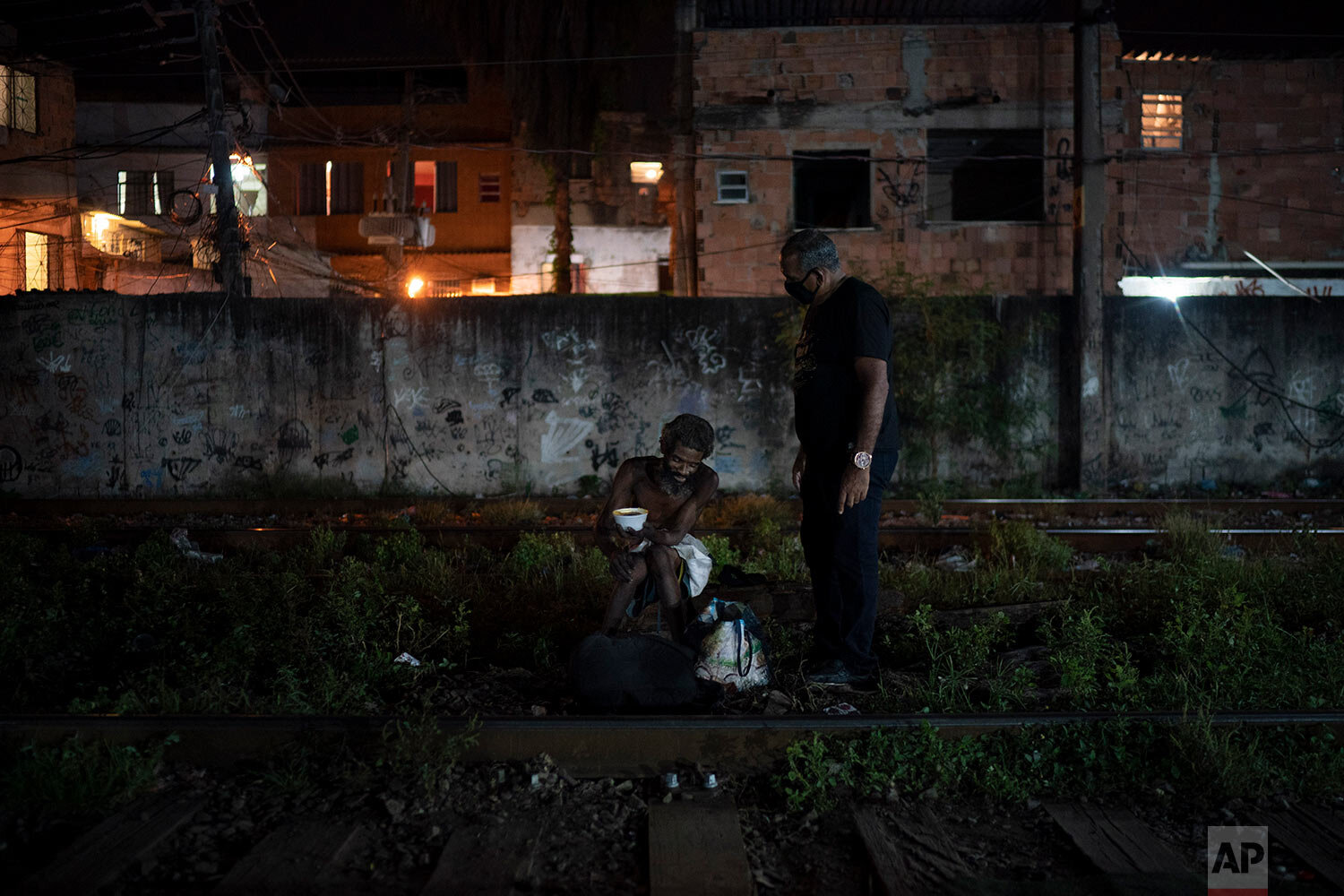  Pastor Celio Ricardo, of the God's Love Evangelical Church and Rehab Center, talks to a drug user in an area known as "cracolandia" or crackland, amid the COVID-19 pandemic in Rio de Janeiro, Brazil, Friday, March 19, 2021. (AP Photo/Felipe Dana) 