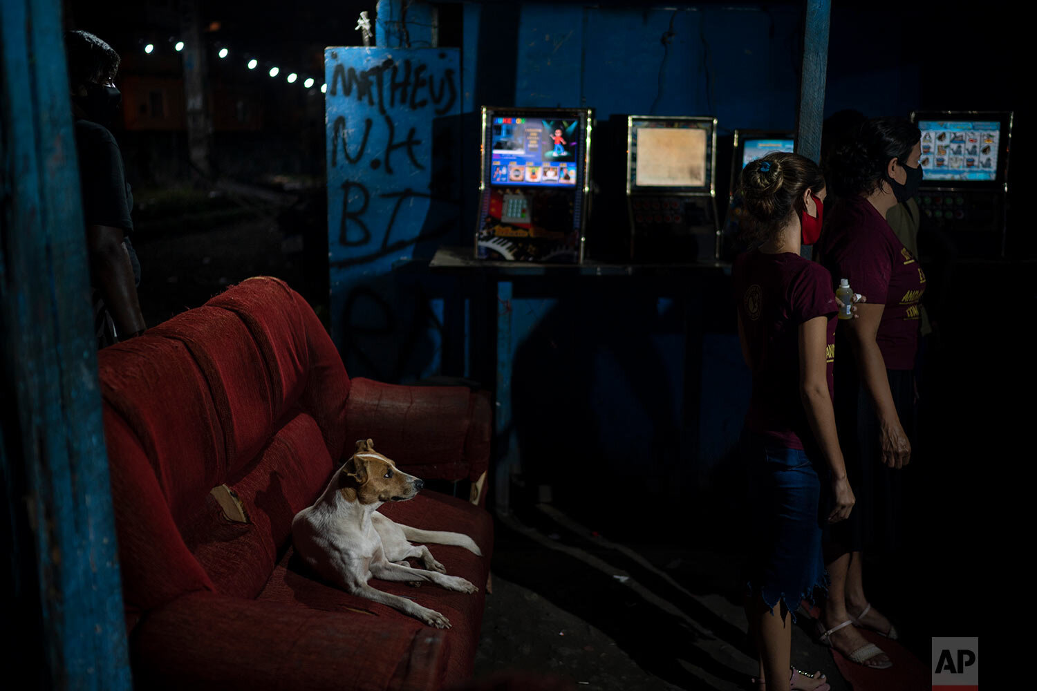  A dog observes as members of the God's Love Evangelical Church and Rehab Center gather for prayer in an area known as "cracolandia" or crackland, amid the COVID-19 pandemic in Rio de Janeiro, Brazil, Friday, March 19, 2021. (AP Photo/Felipe Dana) 