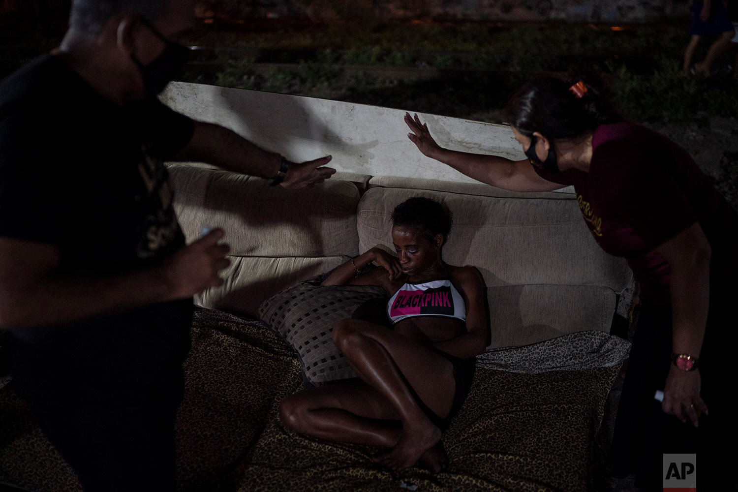  Members of the God's Love Evangelical Church and Rehab Center pray for a woman in an area known as "cracolandia" or crackland, amid the COVID-19 pandemic in Rio de Janeiro, Brazil, Friday, March 19, 2021. (AP Photo/Felipe Dana) 