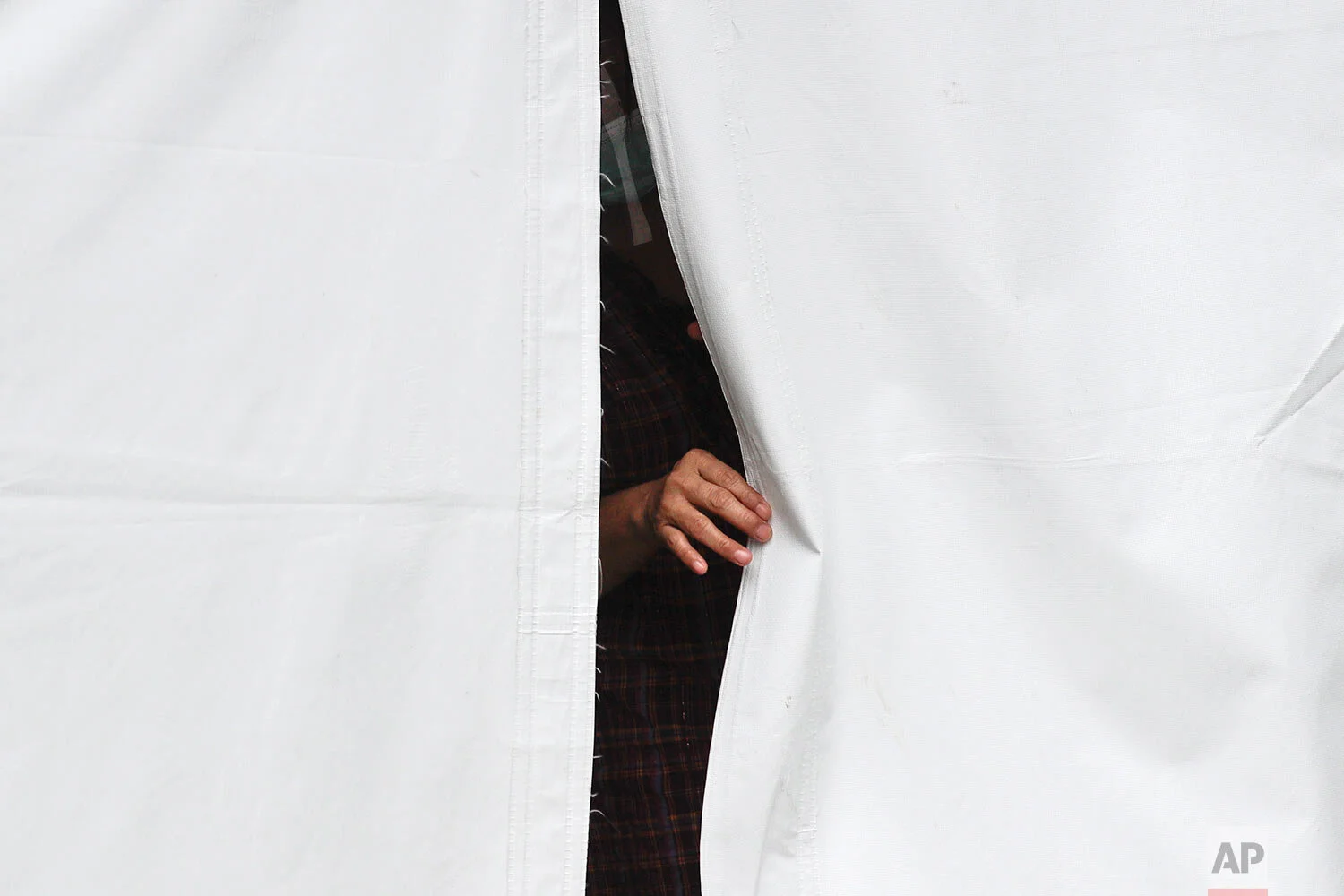 A COVID-19 patient looks out from their isolation tent outside a hospital as cases increase in Manila, Philippines on Monday, April 26, 2021. (AP Photo/Aaron Favila)
