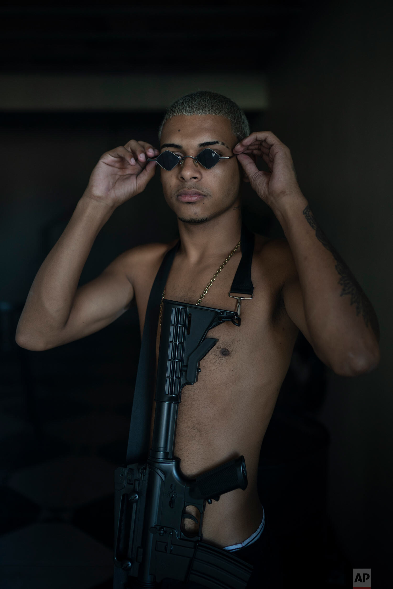 Trap artist Denilson, known as TB holds an Airsoft gun a he