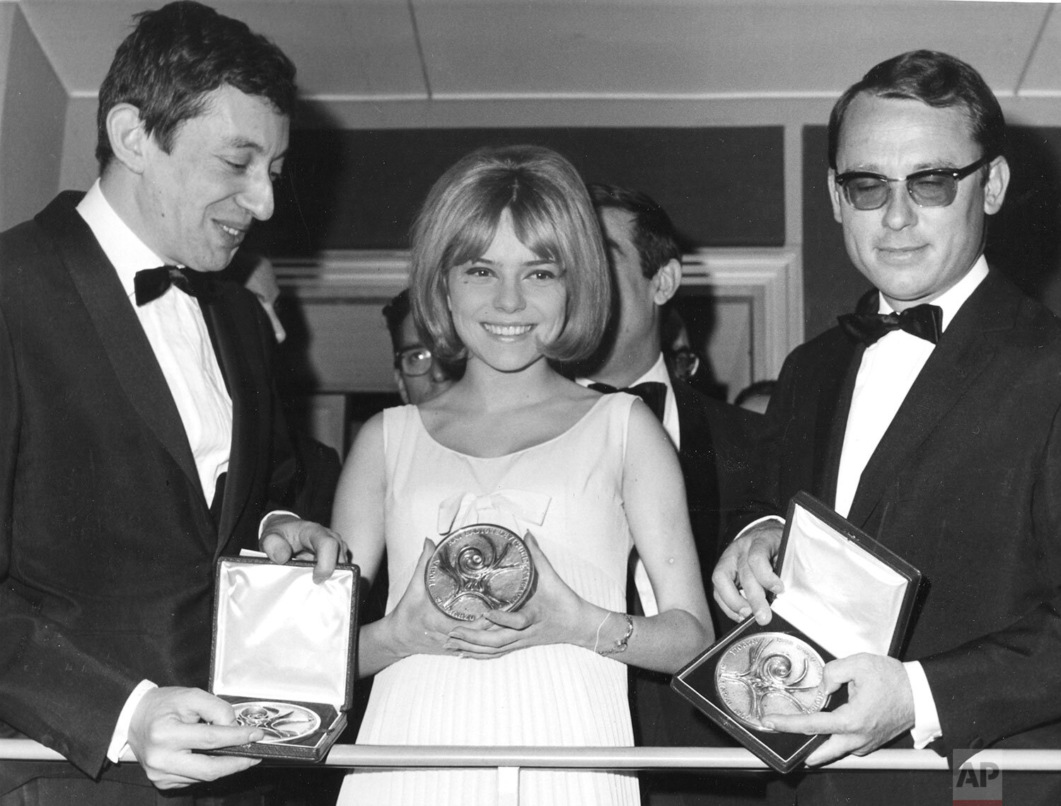  18-year-old French singer France Gall, singing for Luxembourg in the Eurovision Song Contest, proudly presents her winning medal for performing the Serge Gainsbourg, left, song "Poupee de Cire, Poupee de Son" (Wax Doll, Rag Doll) with orchestra dire