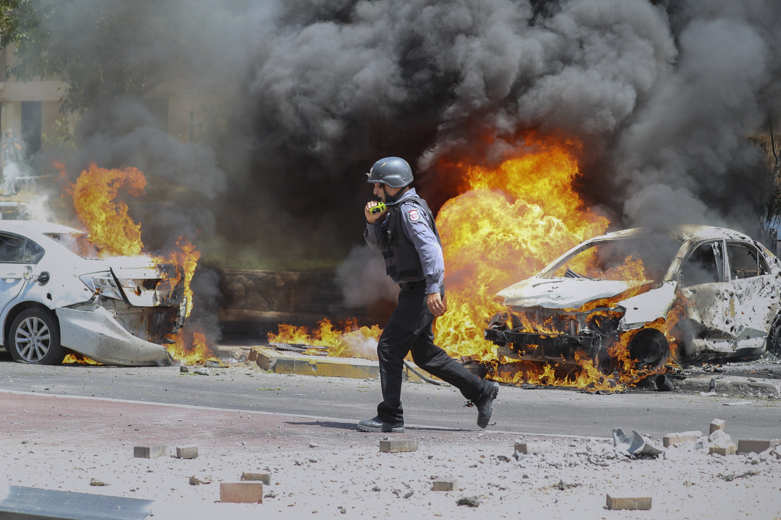  An Israeli firefighter walks next to cars hit by a missile fired from Gaza Strip, in the southern Israeli town of Ashkelon, Tuesday, May 11, 2021. (AP Photo/Ariel Schalit) 