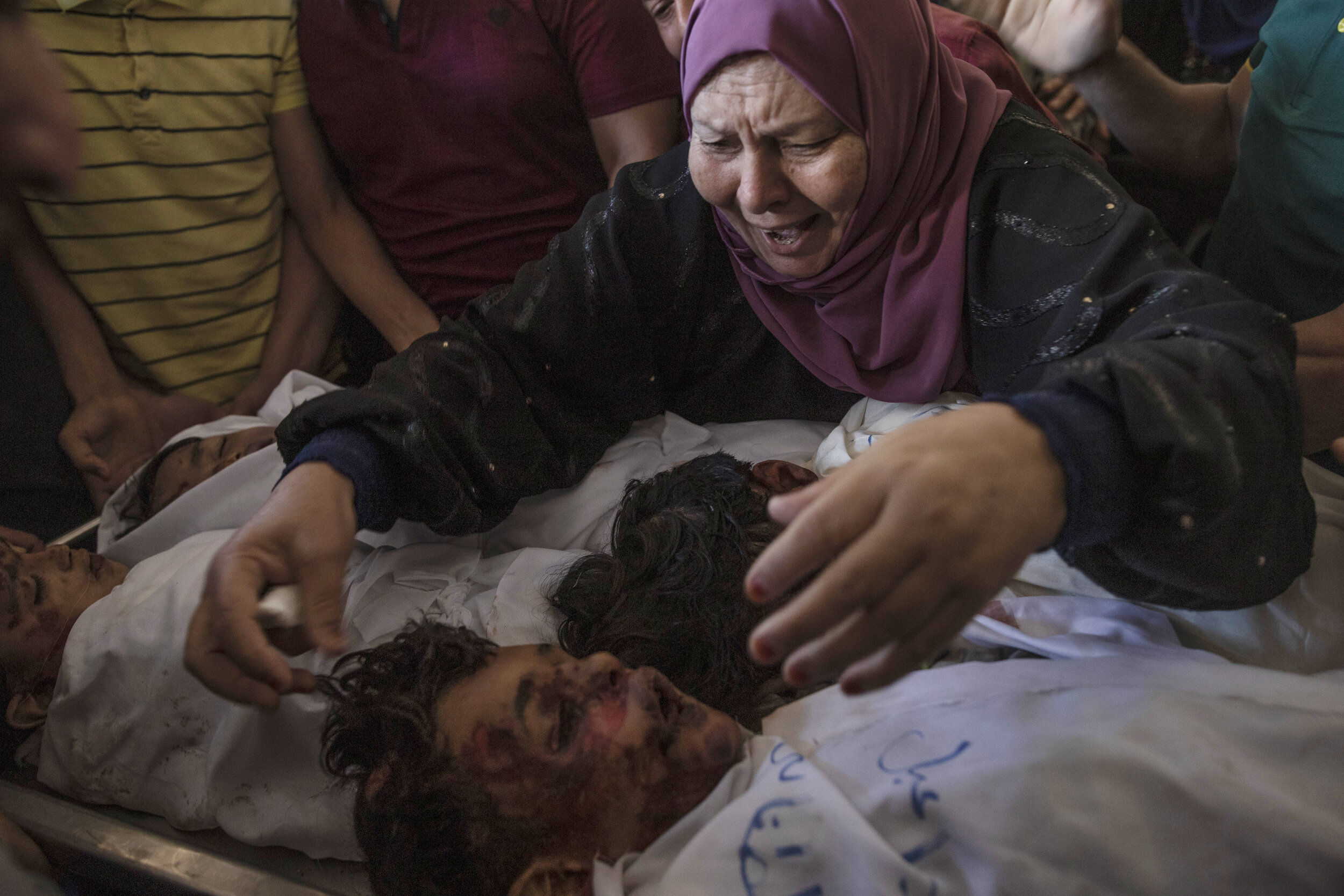  A Palestinian relative mourns over the bodies of four brothers from the Tanani family who were found under the rubble of a destroyed house following Israeli airstrikes in Beit Lahiya, northern Gaza Strip, Friday, May 14, 2021. (AP Photo/Khalil Hamra