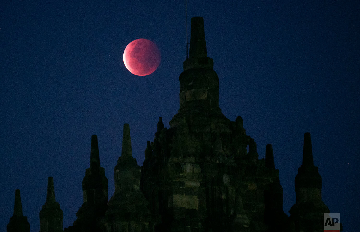  A full moon rises over the 9th century Plaosan Temple as a lunar eclipse takes place in Yogyakarta, Indonesia, Wednesday, May 26, 2021.  (AP Photo/Kasan Kurdi) 