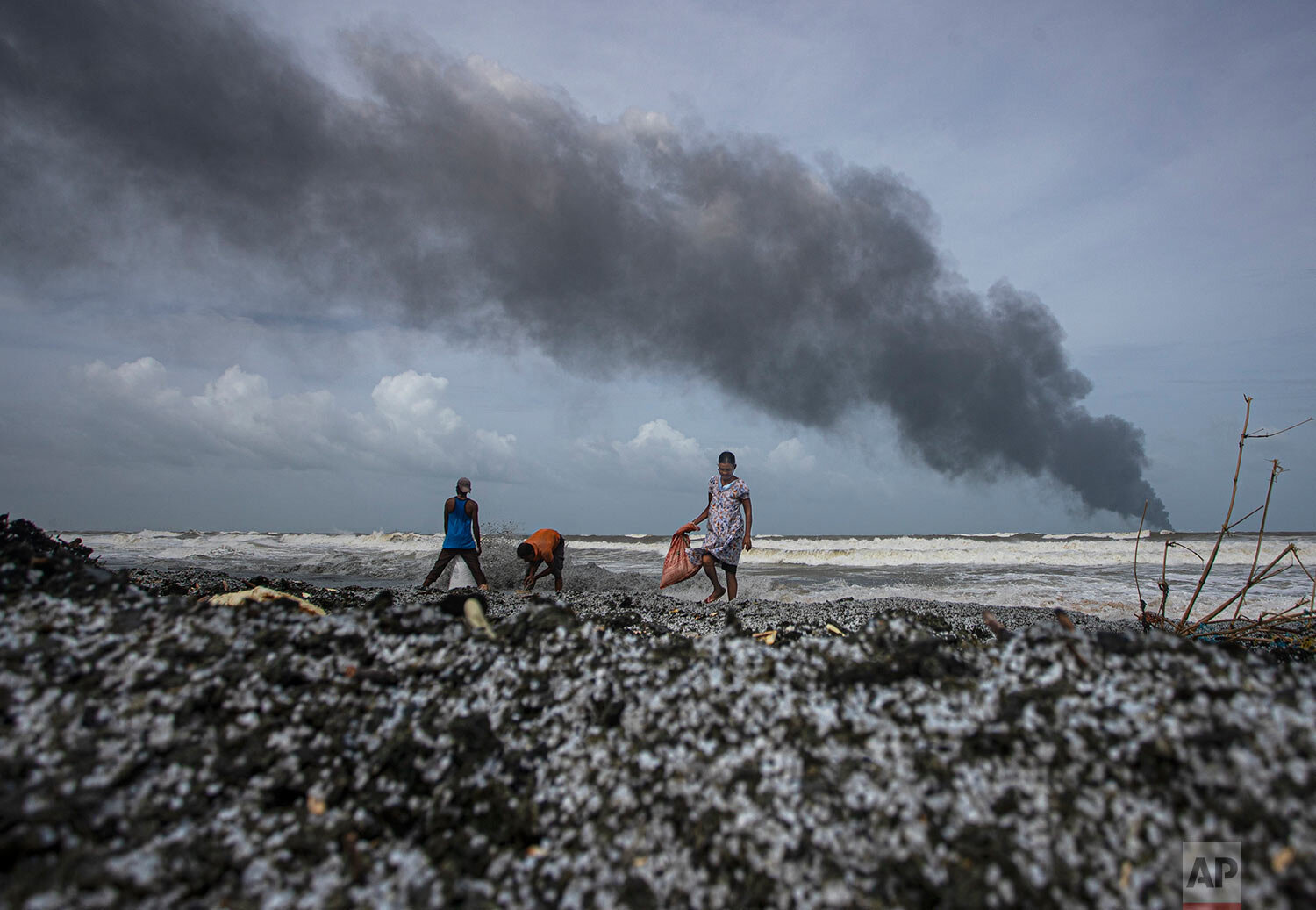  Impoverished Sri Lankans salvage wreck washed off to the shore from the burning Singaporean ship MV X-Press Pearl which is anchored off Colombo port at Kapungoda, out skirts of Colombo, Sri Lanka, Wednesday, May 26, 2021. (AP Photo/Eranga Jayawarden