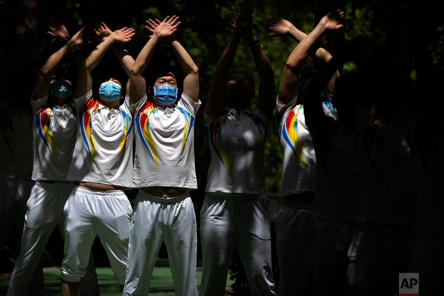  Workers wearing face masks to protect against COVID-19 do group exercises at a park in Beijing, Tuesday, May 25, 2021. (AP Photo/Mark Schiefelbein) 