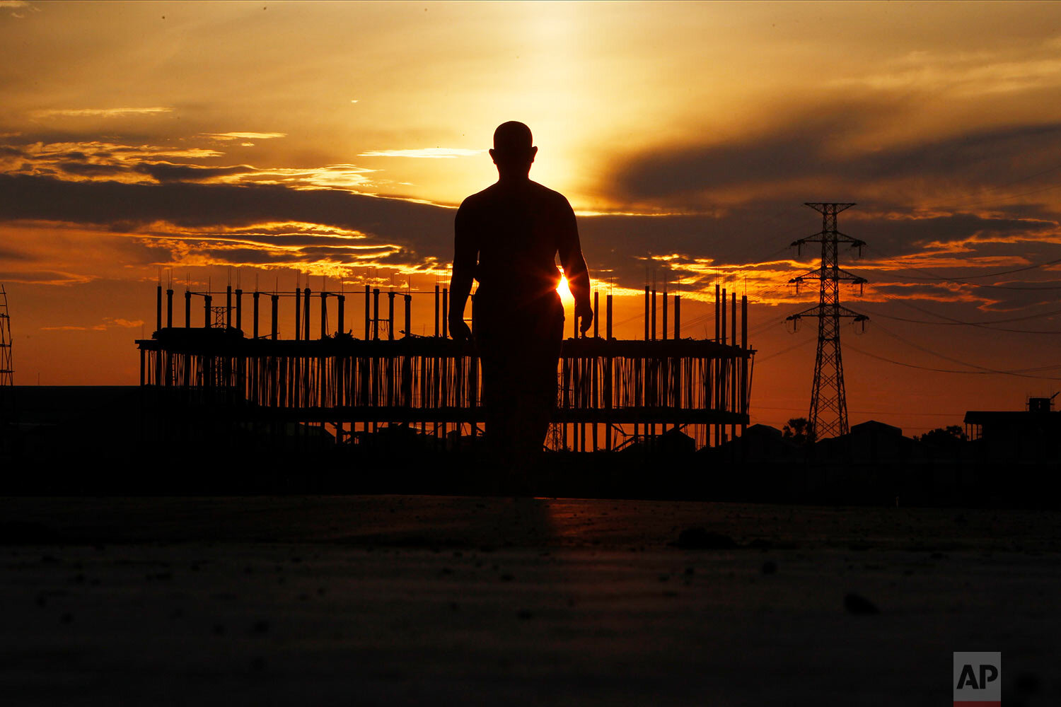  A man is silhouetted during his morning exercise in Chres village on the outskirts of Phnom Penh, Cambodia, Friday, May 21, 2021.  (AP Photo/Heng Sinith) 