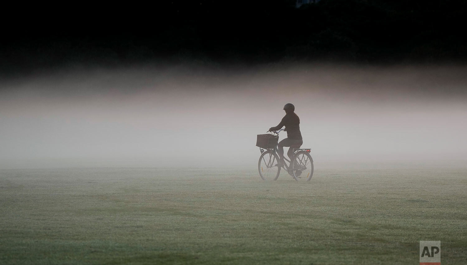  A woman rides her bicycle through a heavy mist in a park as the sun rises in Sydney, Australia, Tuesday, May 25, 2021. (AP Photo/Mark Baker) 