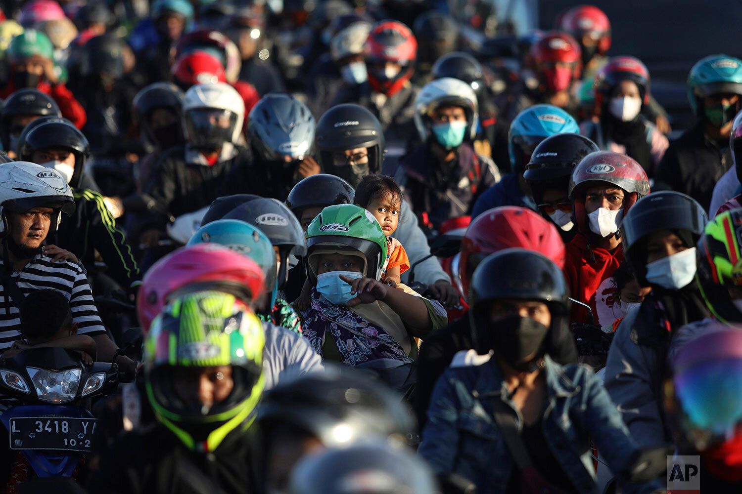  Motorists queue up to cross Suramadu Bridge connecting Java and Madura Island, as they head to their home villages to celebrate Eid al-Fitr holiday that marks the end of Ramadan, in Surabaya, East Java, Indonesia, Wednesday, May 12, 2021. (AP Photo/