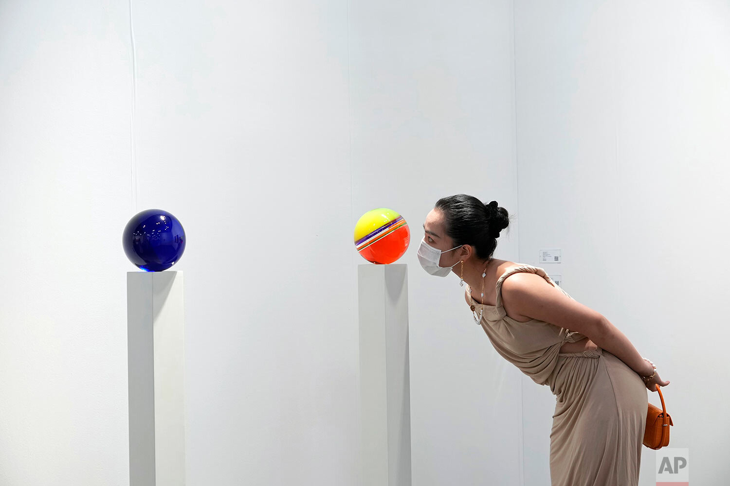  A visitor wearing a face mask takes a close look at an artwork "Untitled, 2019" created by American visual artist Helen Pashgian at Art Basel in Hong Kong Wednesday, May 19, 2021. (AP Photo/Vincent Yu) 