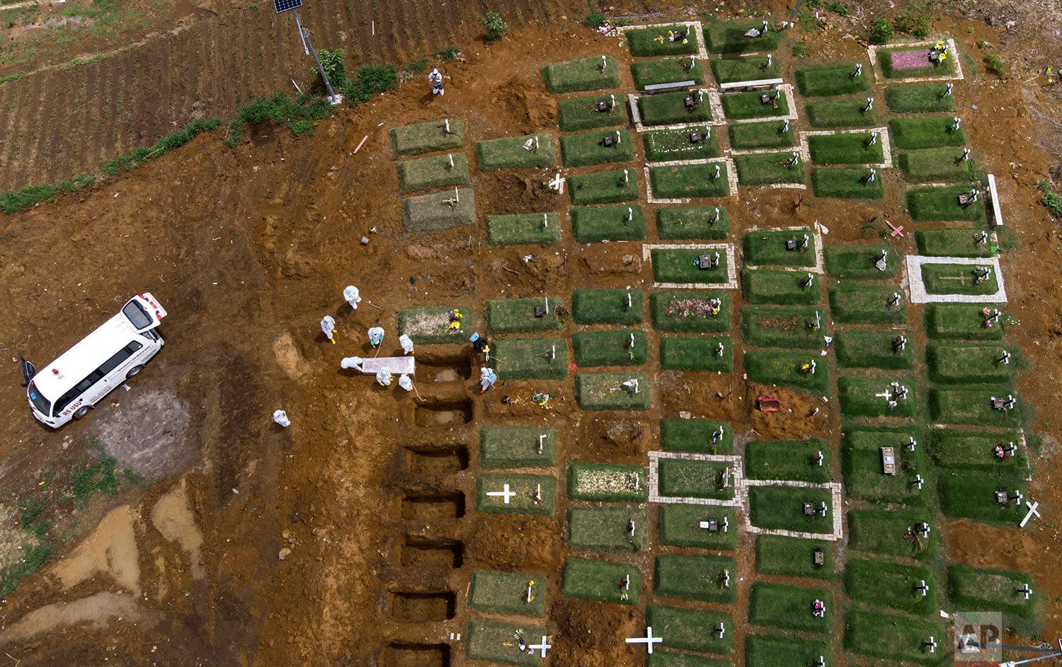  In an aerial view, workers bury a coffin containing the body of a COVID-19 victim at a cemetery reserved for those who died of complications related to coronavirus in Medan, North Sumatra, Indonesia, Sunday, May 2, 2021. (AP Photo/Binsar Bakkara) 