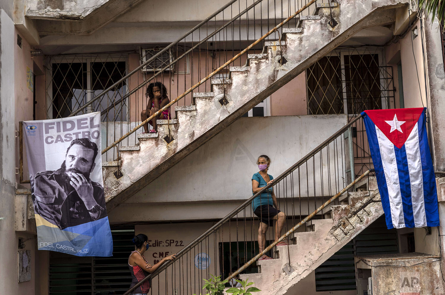  People wait to be vaccinated with the locally made Abdala vaccine for COVID-19 at a doctors' office decorated with an image of Fidel Castro and a Cuban flag in the Alamar neighborhood of Havana, Cuba, May 14, 2021. (AP Photo/Ramon Espinosa) 