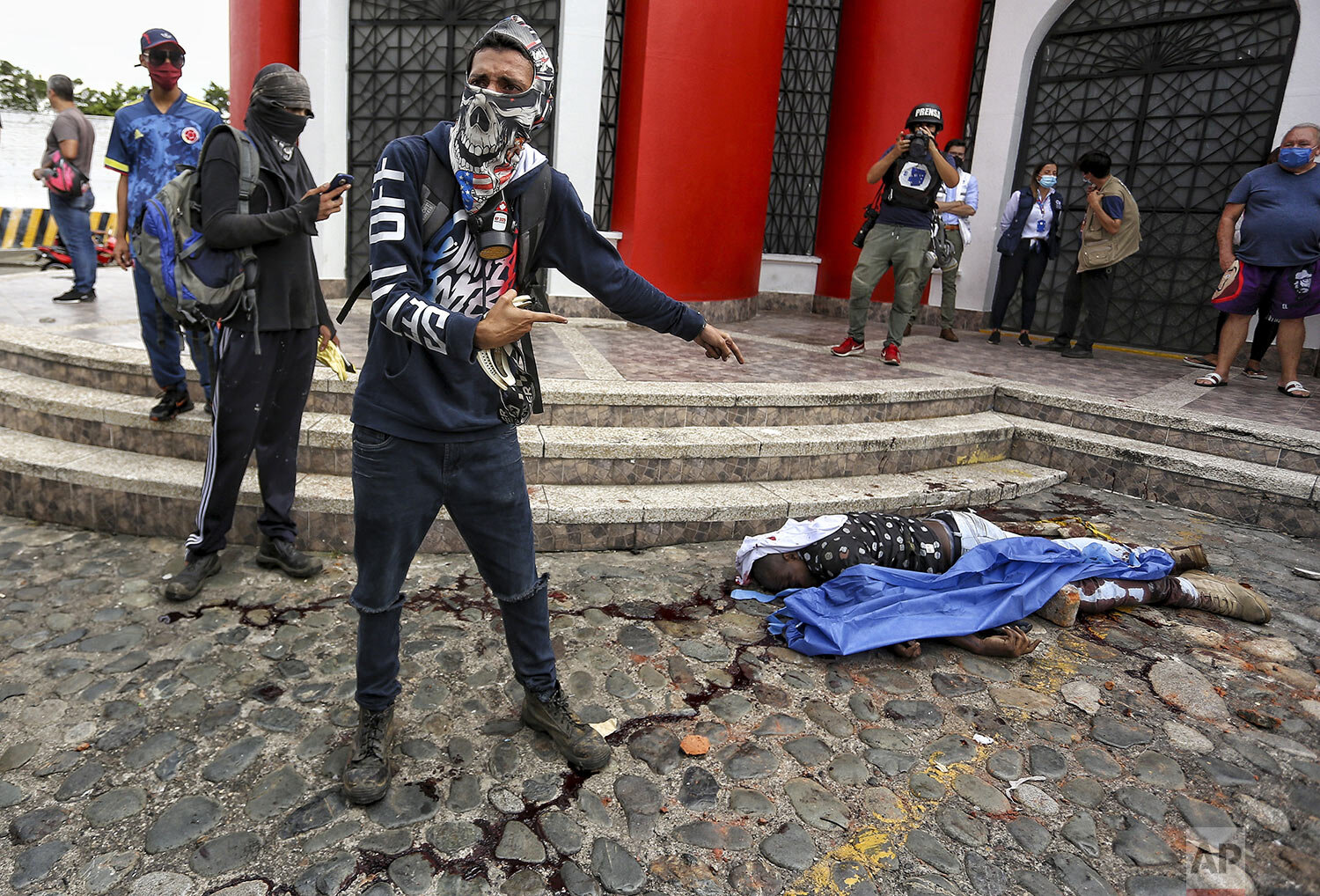 Anti-government protesters stand next to the body of Fredy Bermudez, an official of the Attorney General's office who protesters killed in retaliation for fatally shooting two protesters at a roadblock set up by demonstrators in Cali, Colombia, May 