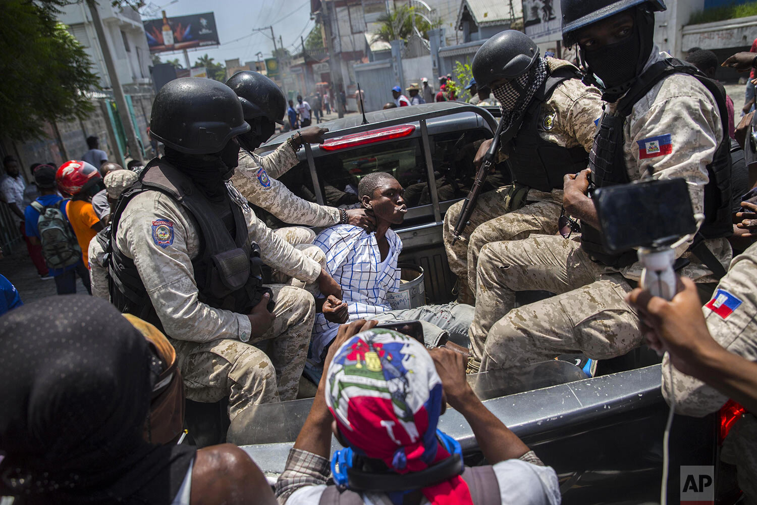  A man is detained by the police, accused of theft by demonstrators, during a protest demanding the resignation of President Jovenel Moise and against an upcoming constitutional referendum in Port-au-Prince, Haiti, May 18, 2021. (AP Photo/Joseph Odel