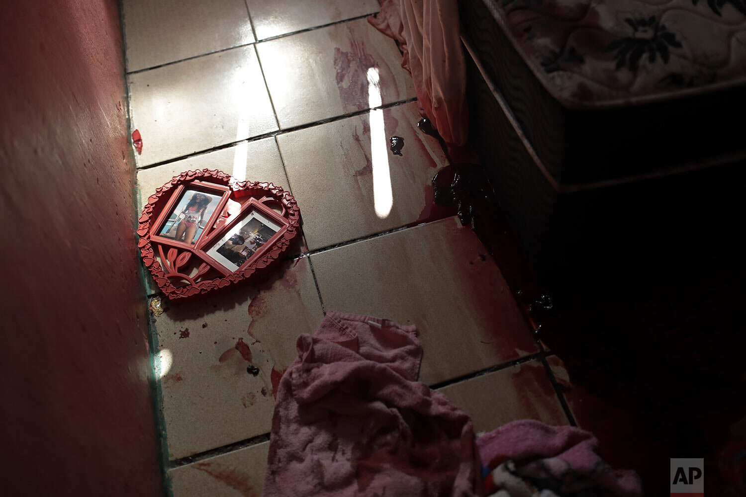  A heart shaped picture frame lays on a blood covered floor inside a home in the aftermath of a police raid targeting drug traffickers that killed at least 25 people in the Jacarezinho favela of Rio de Janeiro, Brazil, May 6, 2021. (AP Photo/Silvia I