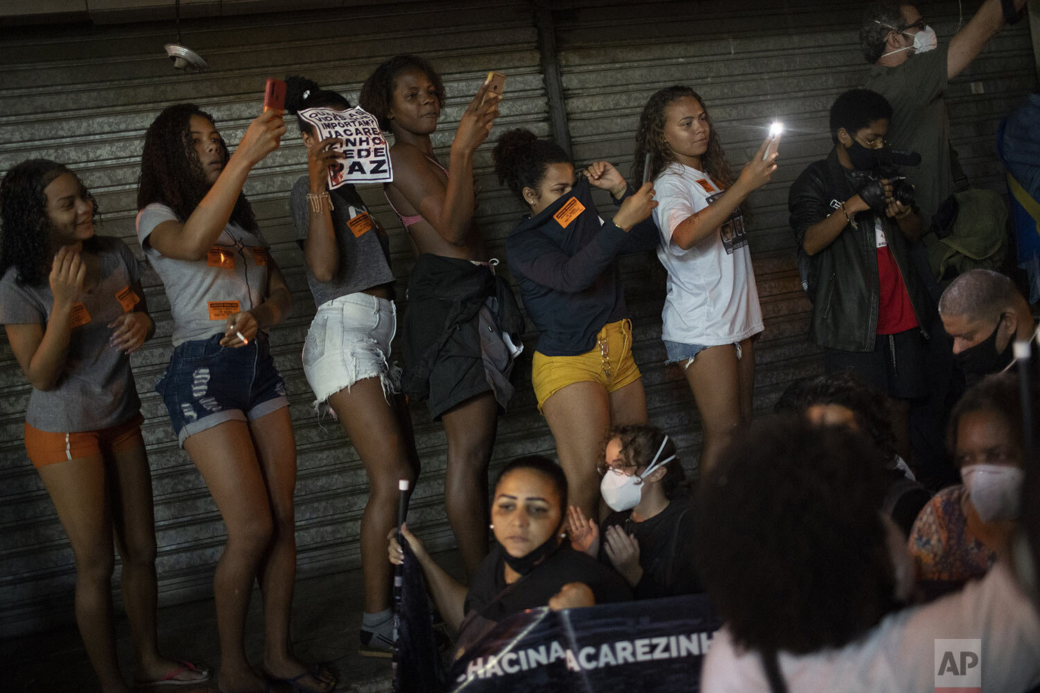  Women take photos of a protest the day after a deadly police operation that killed at least 25 people in the Jacarezinho favela of Rio de Janeiro, Brazil, May 7, 2021. (AP Photo/Silvia Izquierdo) 