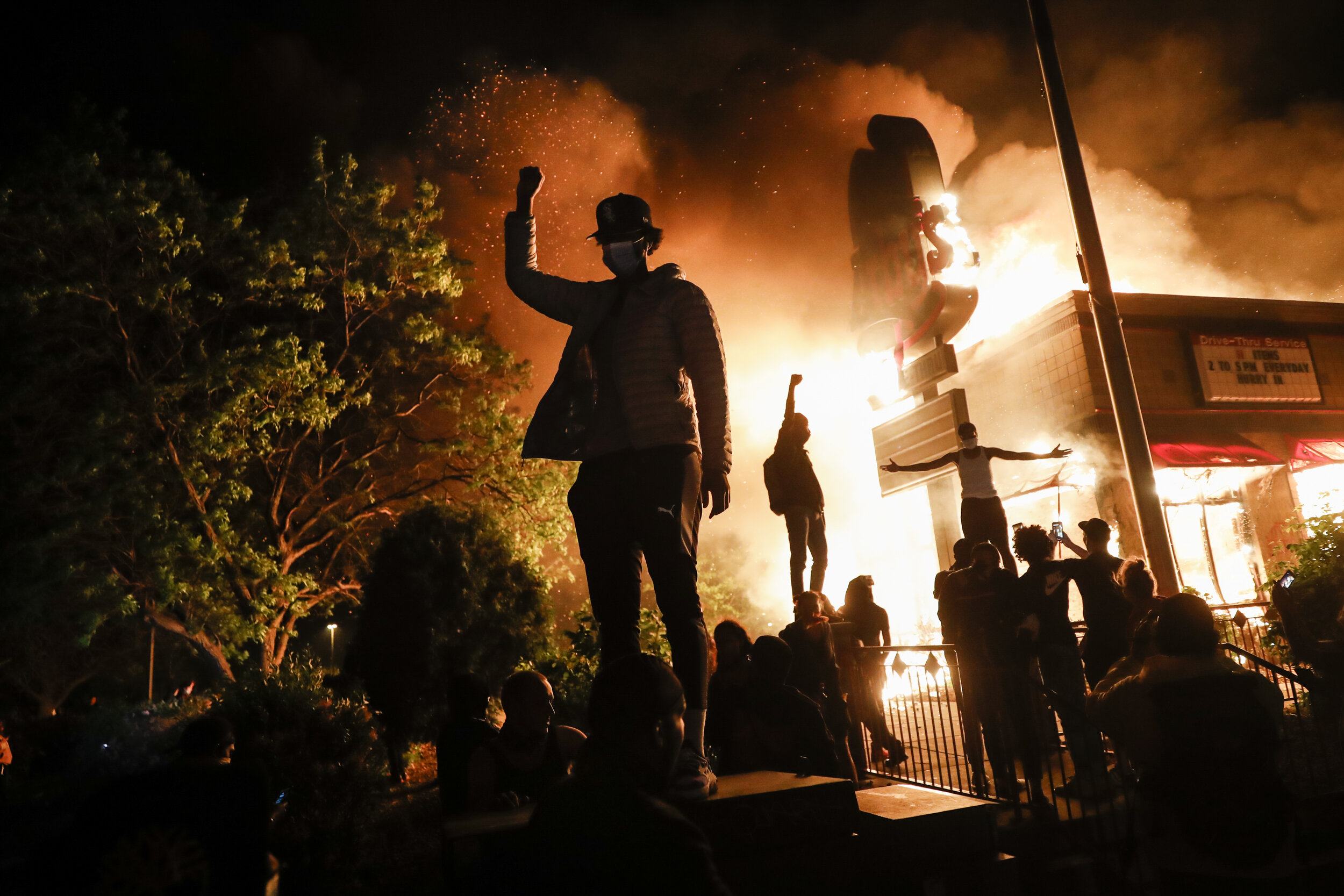  Protesters gather in front of a burning fast food restaurant, May 29, 2020, in Minneapolis. Protests over the death of George Floyd, a black man who died in police custody, broke out in Minneapolis for a third straight night. (AP Photo/John Minchill