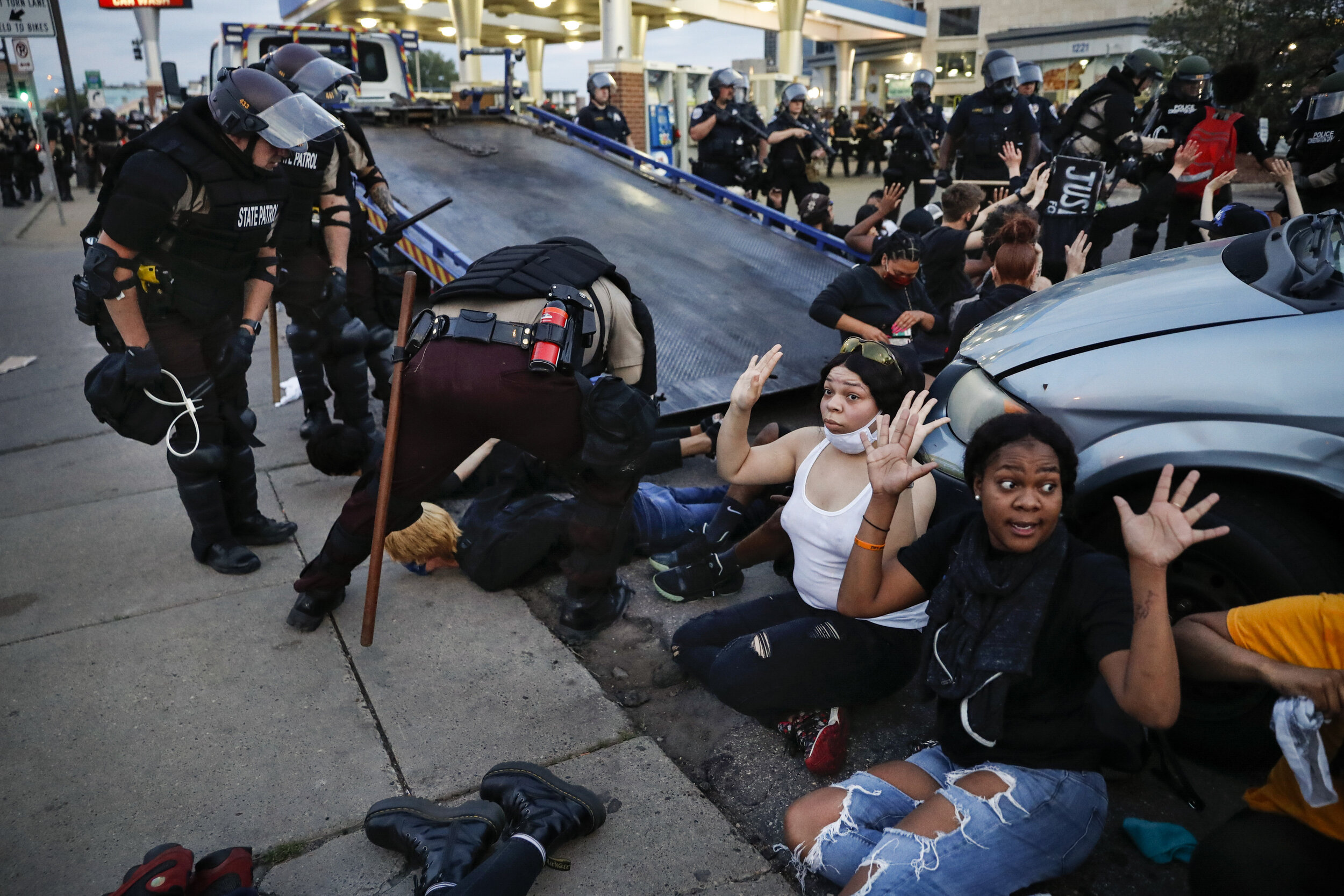  Protesters raise their hands on command from police as they are detained prior to arrest and processing at a gas station on South Washington Street, May 31, 2020, in Minneapolis. (AP Photo/John Minchillo) 