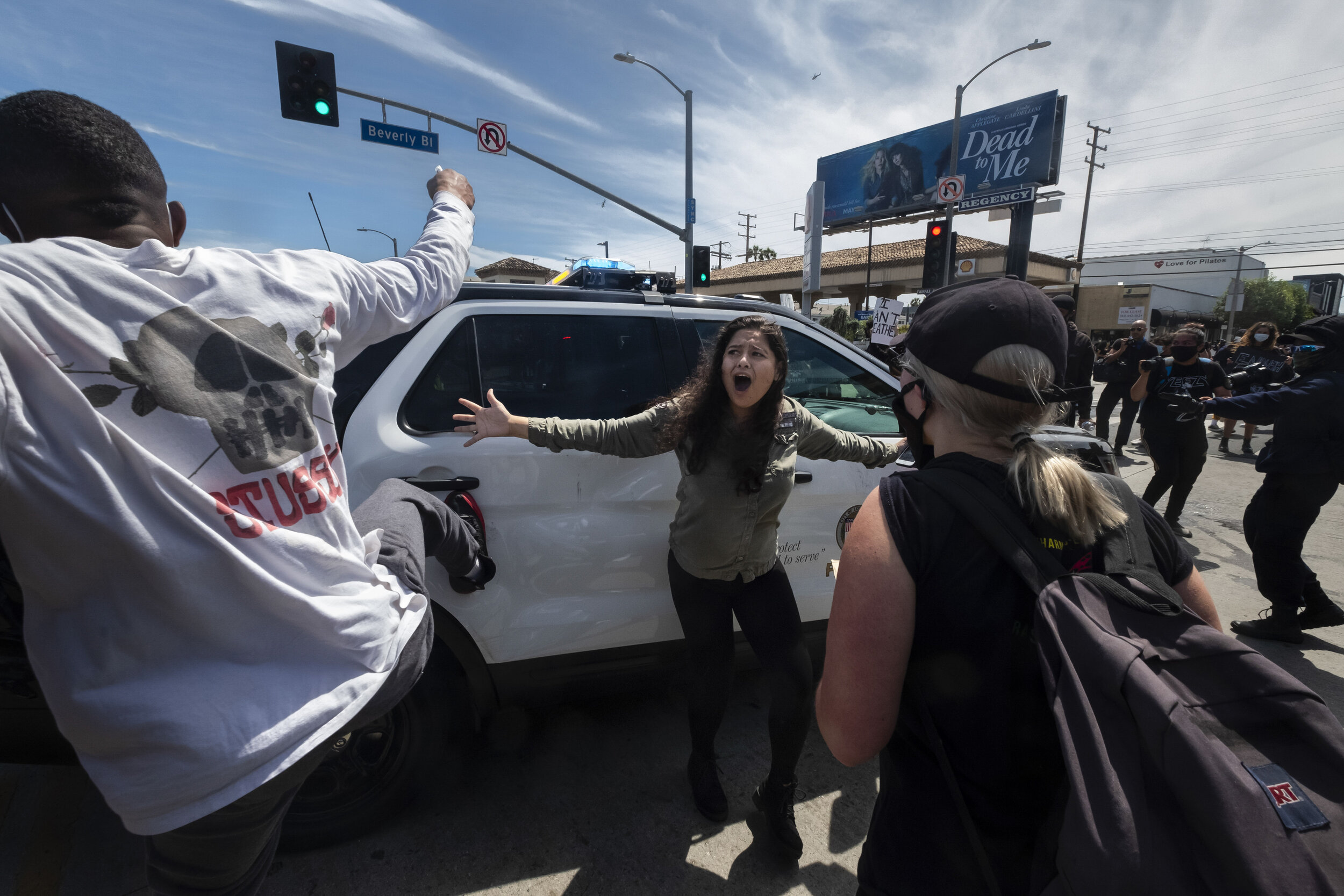  A protester, center, tries to stop others from attacking a police vehicle during a protest over the death of George Floyd in Los Angeles, May 30, 2020.  (AP Photo/Ringo H.W. Chiu) 