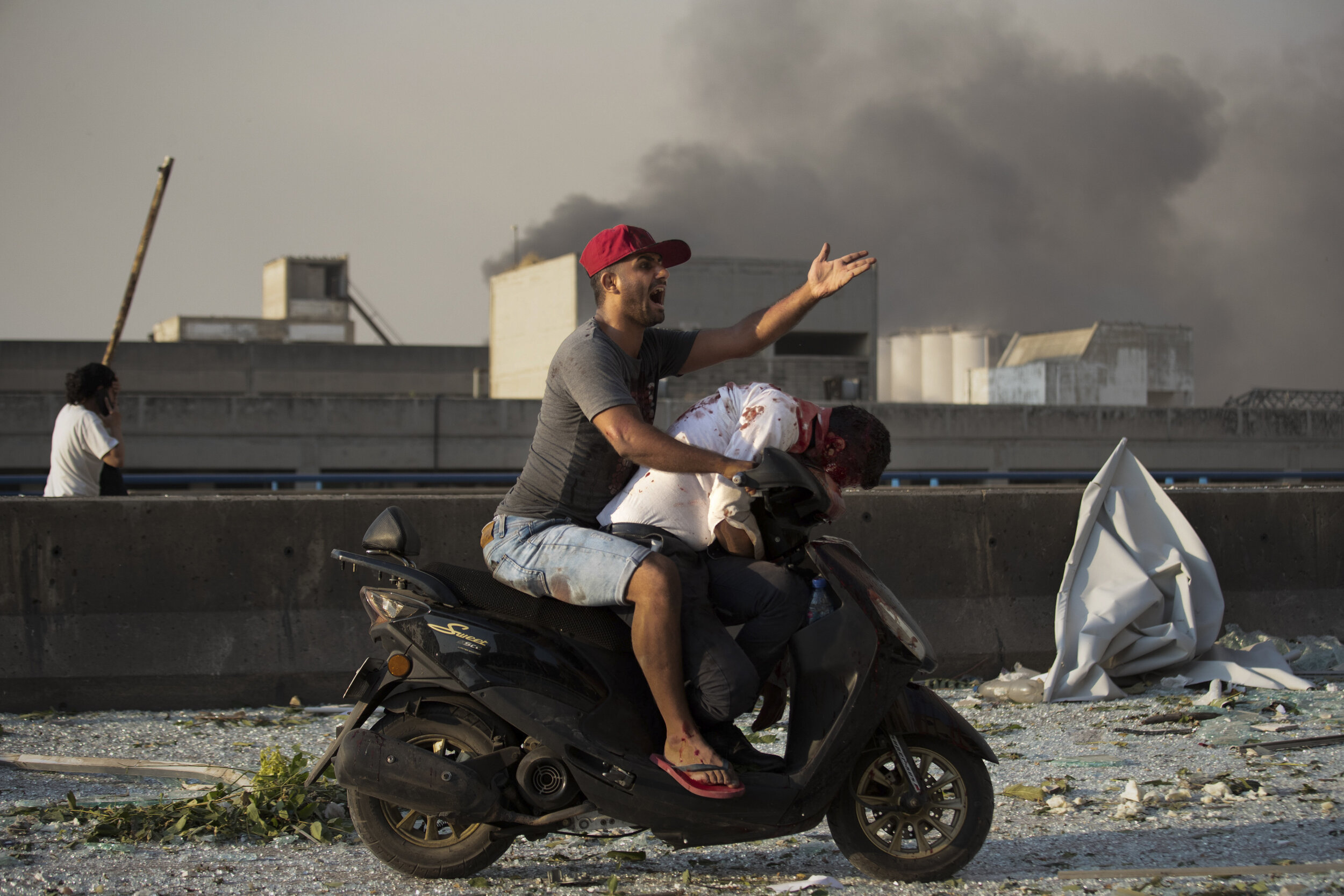  A man evacuates an injured person after a massive explosion in Beirut, Lebanon, Aug. 4, 2020. AP Photo by Hassan Ammar 