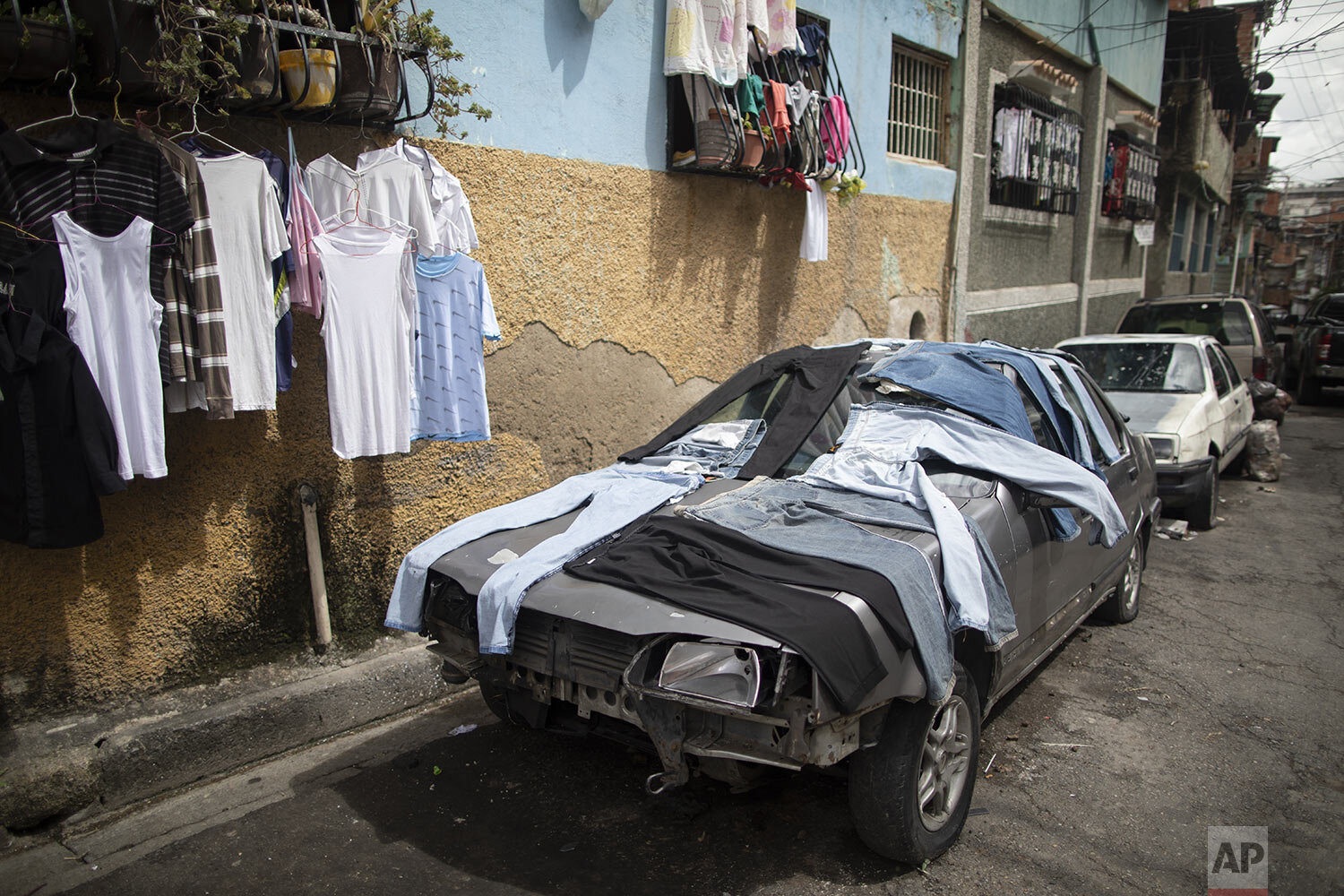  An out of commission car is used to dry laundry in the Petare neighborhood of Caracas, Venezuela, June 10, 2021. (AP Photo/Ariana Cubillos) 