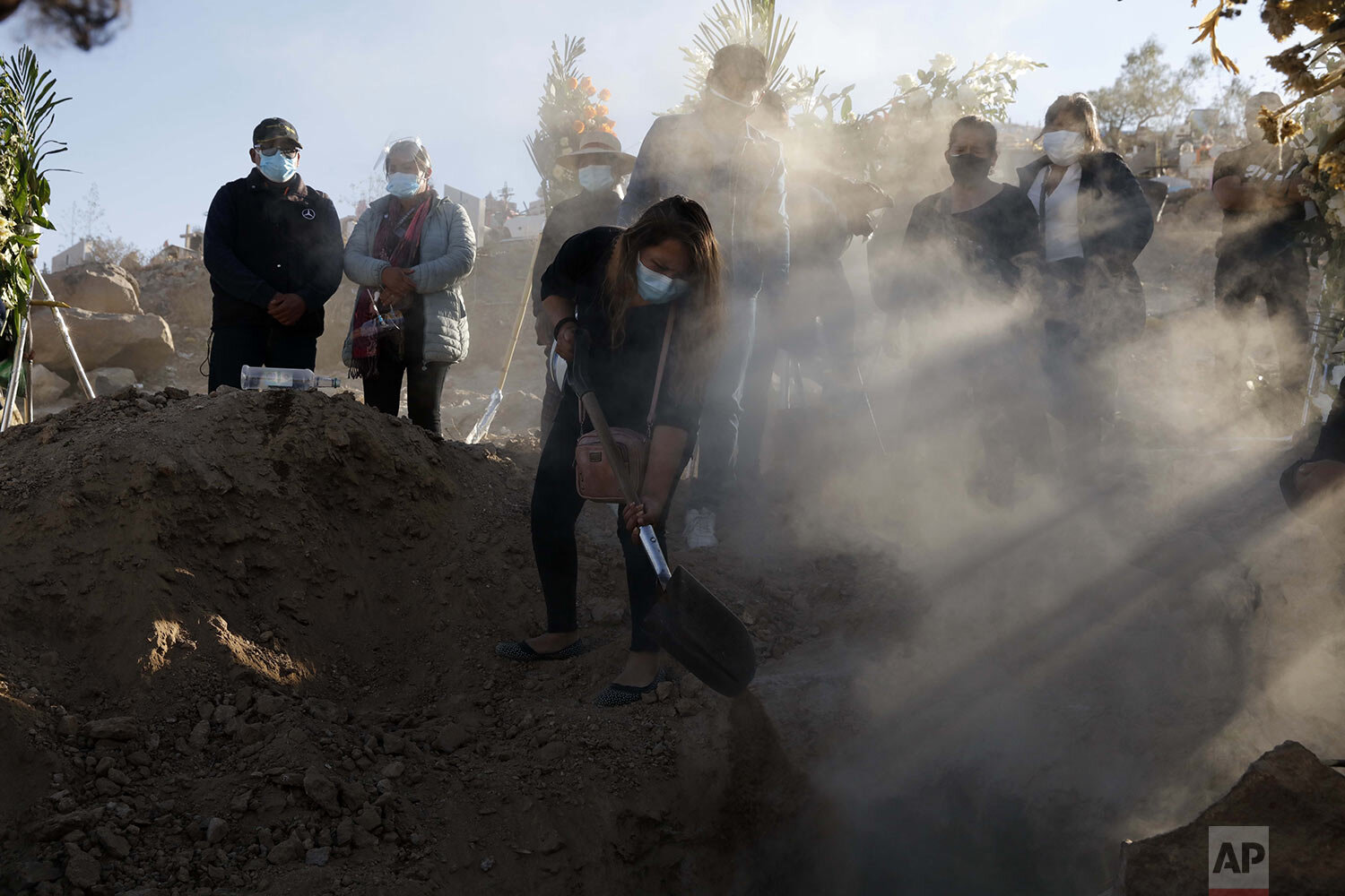  A person shovels dirt into the grave of their family member, Giro Quispe, who died from complications related to COVID-19 at El Cebollar cemetery in Arequipa, Peru, June 25, 2021, during a strict city lockdown. (AP Photo/Guadalupe Pardo) 